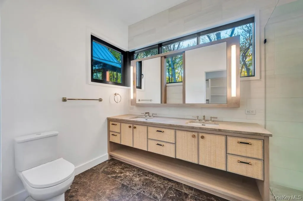 Full bath with double vanity and baseboards Full bath with double vanity and baseboards