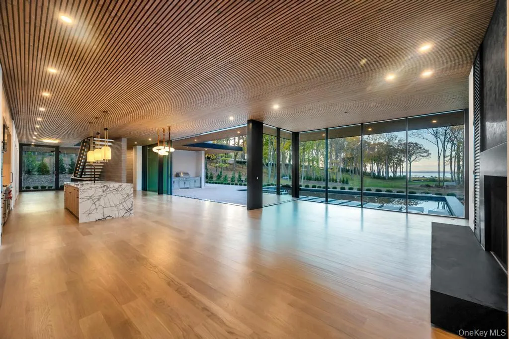 Unfurnished living room with expansive windows and light wood-type flooring Unfurnished living room with expansive windows and light wood-type flooring