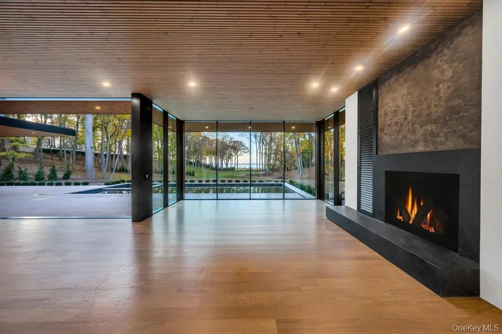 Unfurnished living room featuring floor to ceiling windows, wood finished floors, a fireplace, recessed lighting, and wood ceiling Unfurnished living room featuring floor to ceiling windows, wood finished floors, a fireplace, recessed lighting, and wood ceiling