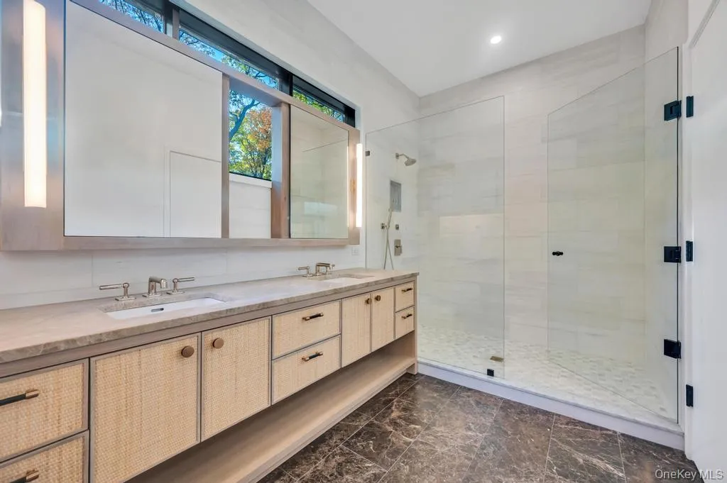 Bathroom featuring a stall shower and double vanity Bathroom featuring a stall shower and double vanity