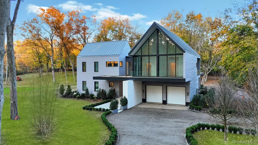 Contemporary home featuring a garage, driveway, and a front yard Contemporary home featuring a garage, driveway, and a front yard