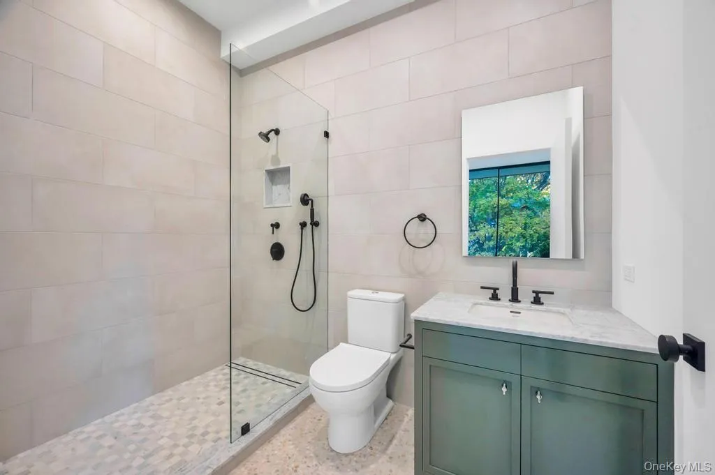 Bathroom with walk in shower, vanity, and tile walls Bathroom with walk in shower, vanity, and tile walls