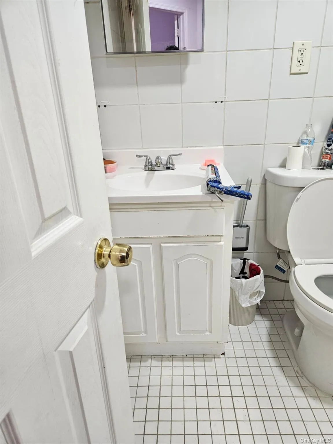 Half bath with vanity, light tile patterned floors, tile walls, and backsplash Half bath with vanity, light tile patterned floors, tile walls, and backsplash