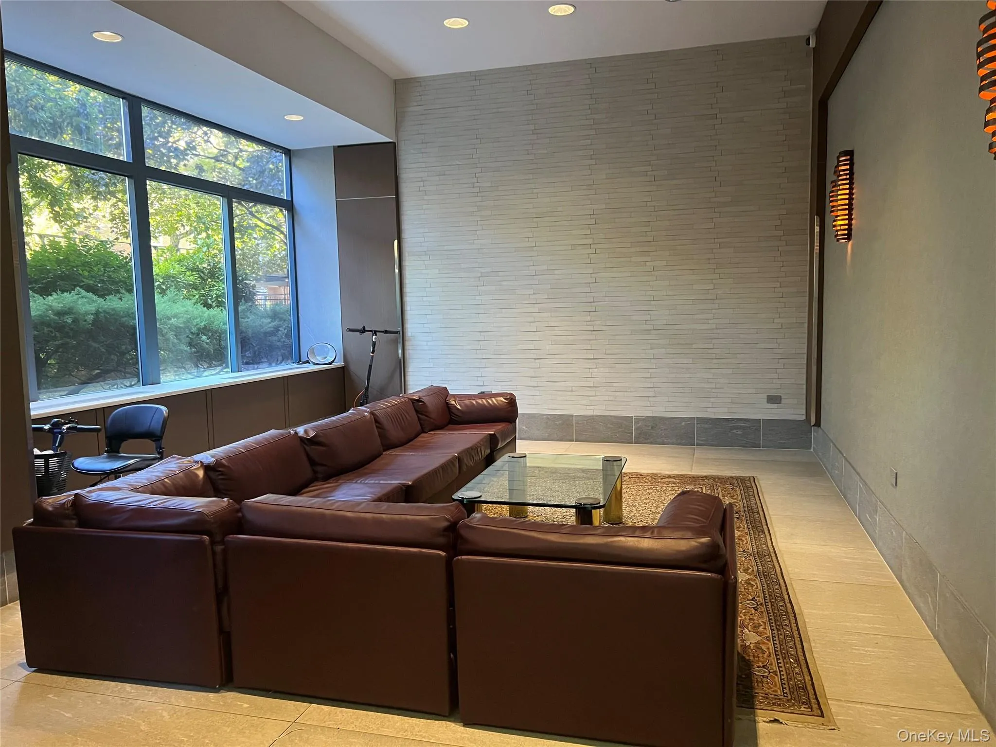 Living room featuring recessed lighting, tile walls, light tile patterned floors, and an accent wall Living room featuring recessed lighting, tile walls, light tile patterned floors, and an accent wall