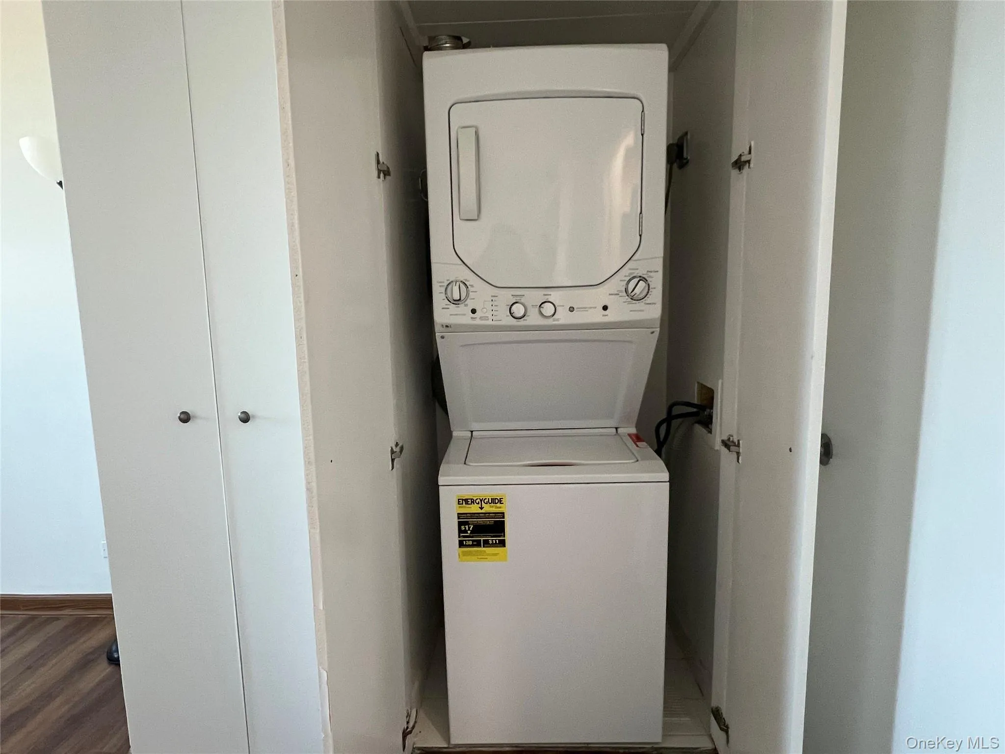 Washroom featuring stacked washer / dryer and baseboards Washroom featuring stacked washer / dryer and baseboards