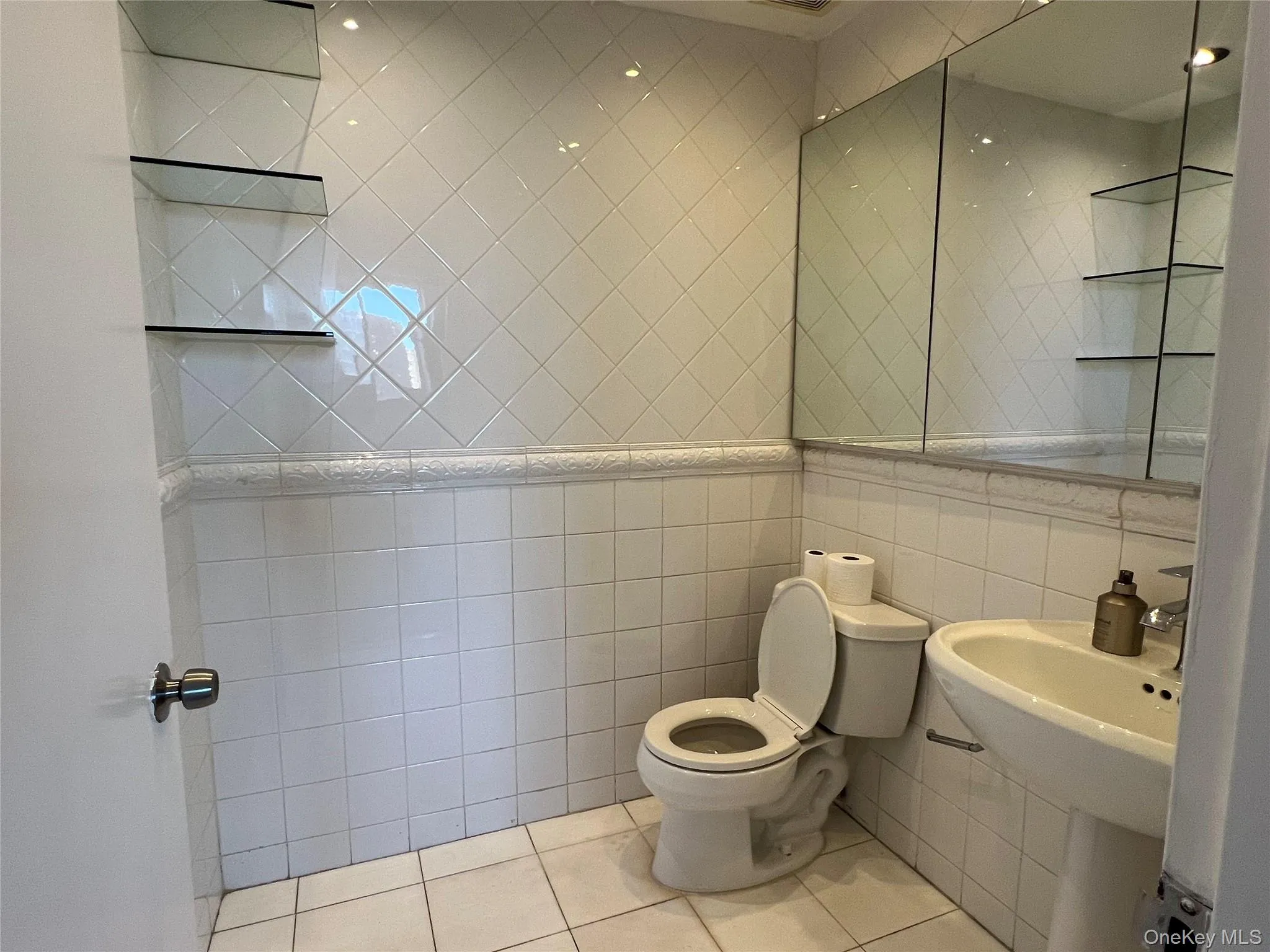 Half bath with tile walls and light tile patterned floors Half bath with tile walls and light tile patterned floors