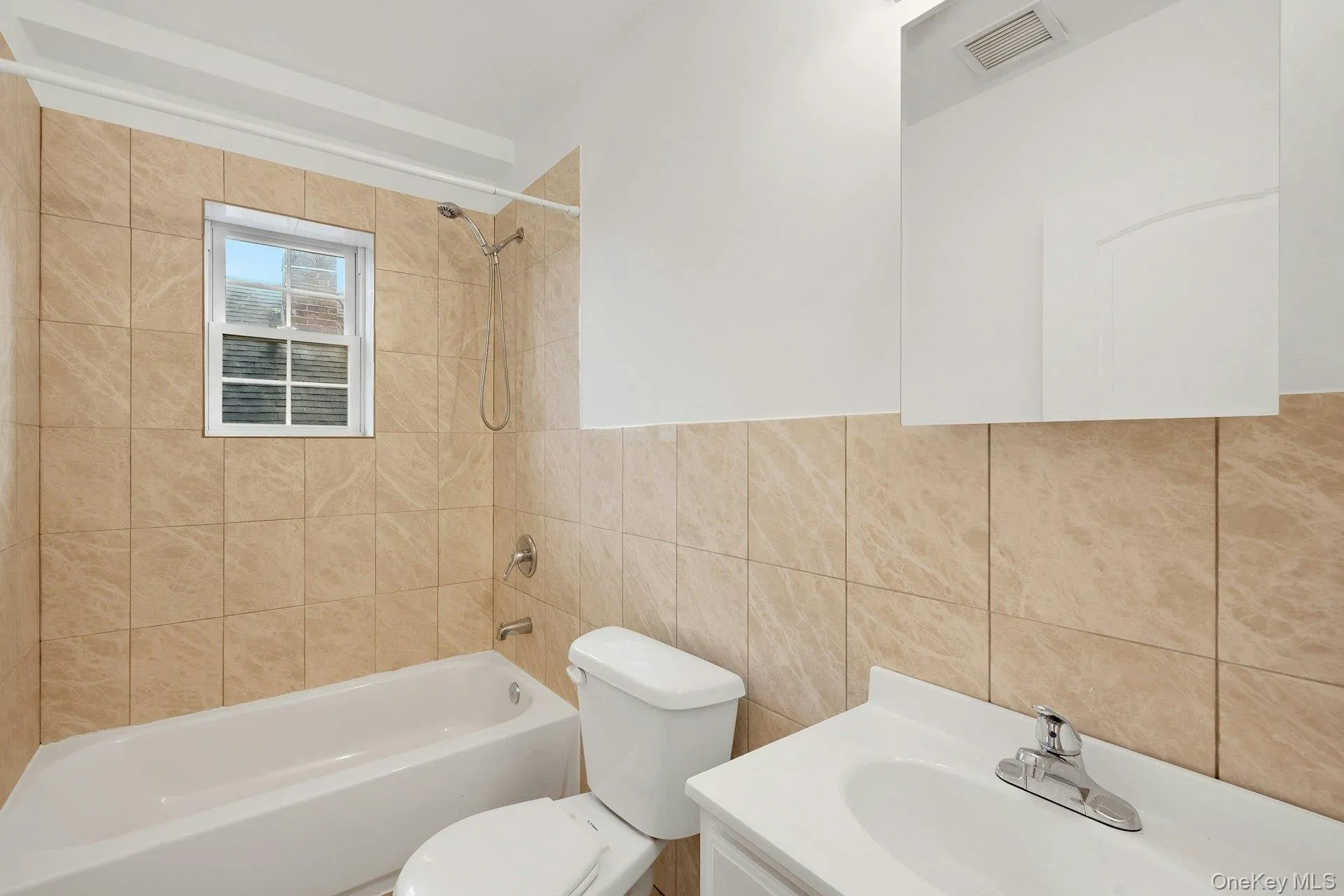 Full bath with vanity, tile walls, and washtub / shower combination Full bath with vanity, tile walls, and washtub / shower combination