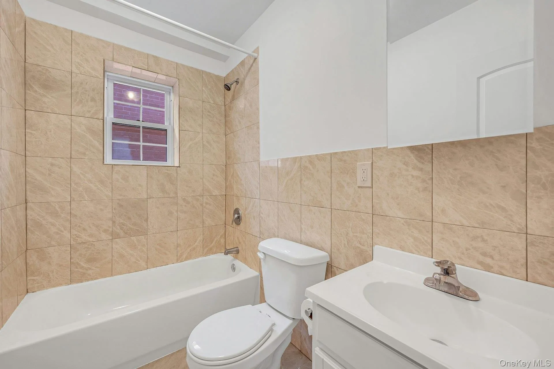 Full bathroom with vanity, shower / tub combination, and tile walls Full bathroom with vanity, shower / tub combination, and tile walls