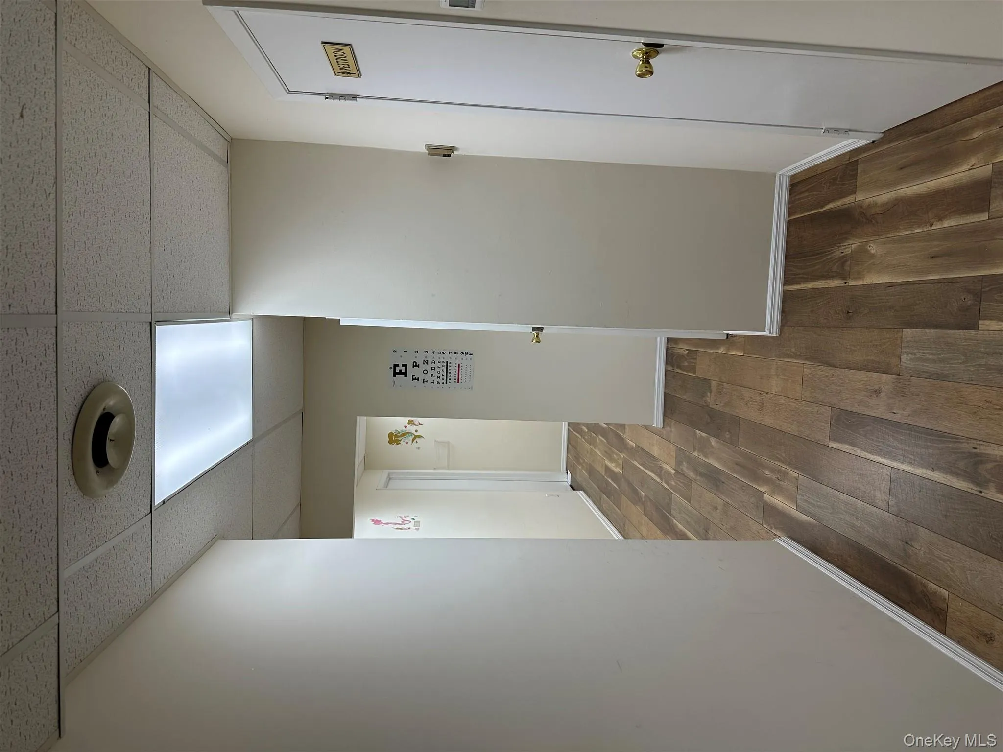 Hallway featuring a paneled ceiling and dark wood-type flooring Hallway featuring a paneled ceiling and dark wood-type flooring