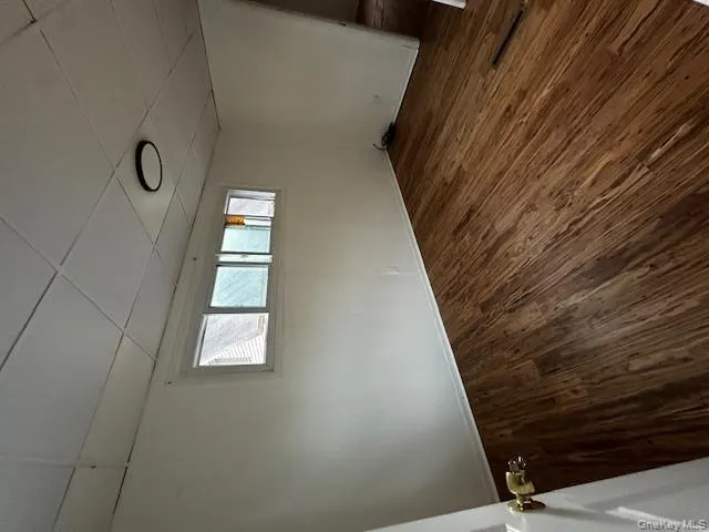 Spare room featuring a drop ceiling, dark wood-type flooring, and healthy amount of natural light Spare room featuring a drop ceiling, dark wood-type flooring, and healthy amount of natural light