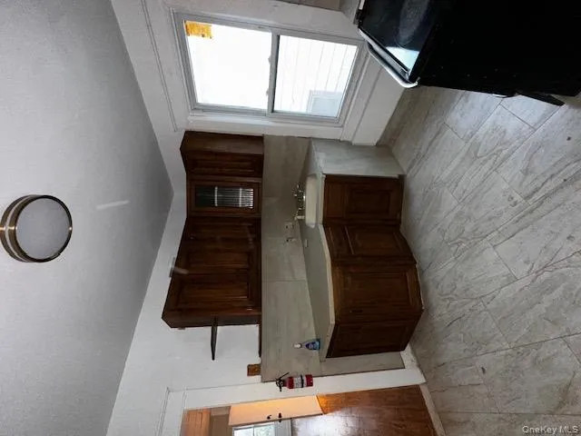 Kitchen with light countertops, stove, dark brown cabinetry, decorative backsplash, and open shelves Kitchen with light countertops, stove, dark brown cabinetry, decorative backsplash, and open shelves