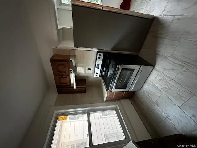 Kitchen featuring stainless steel electric stove, refrigerator, light countertops, and extractor fan Kitchen featuring stainless steel electric stove, refrigerator, light countertops, and extractor fan
