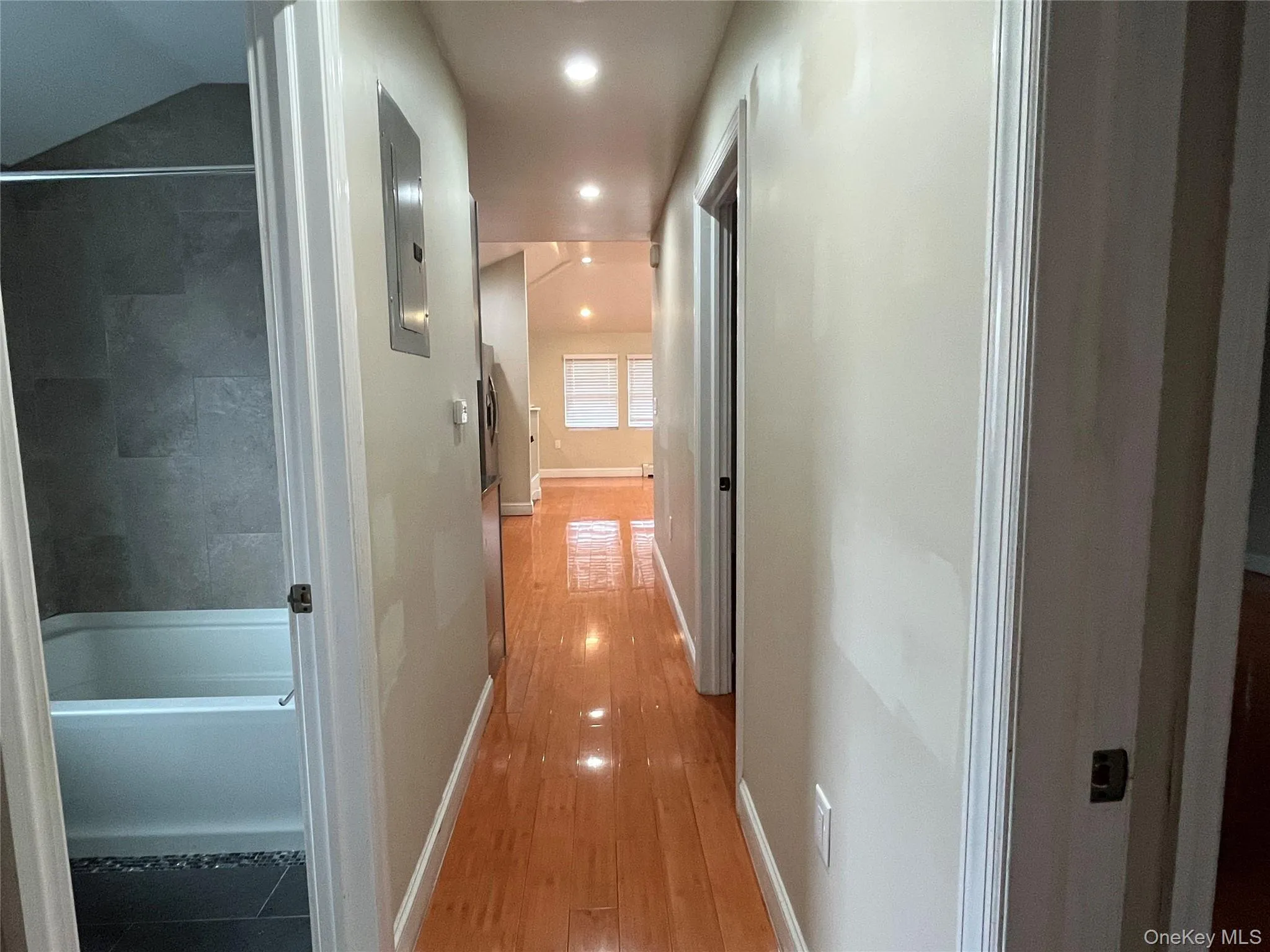 Hallway featuring recessed lighting, light wood-style flooring, and electric panel Hallway featuring recessed lighting, light wood-style flooring, and electric panel