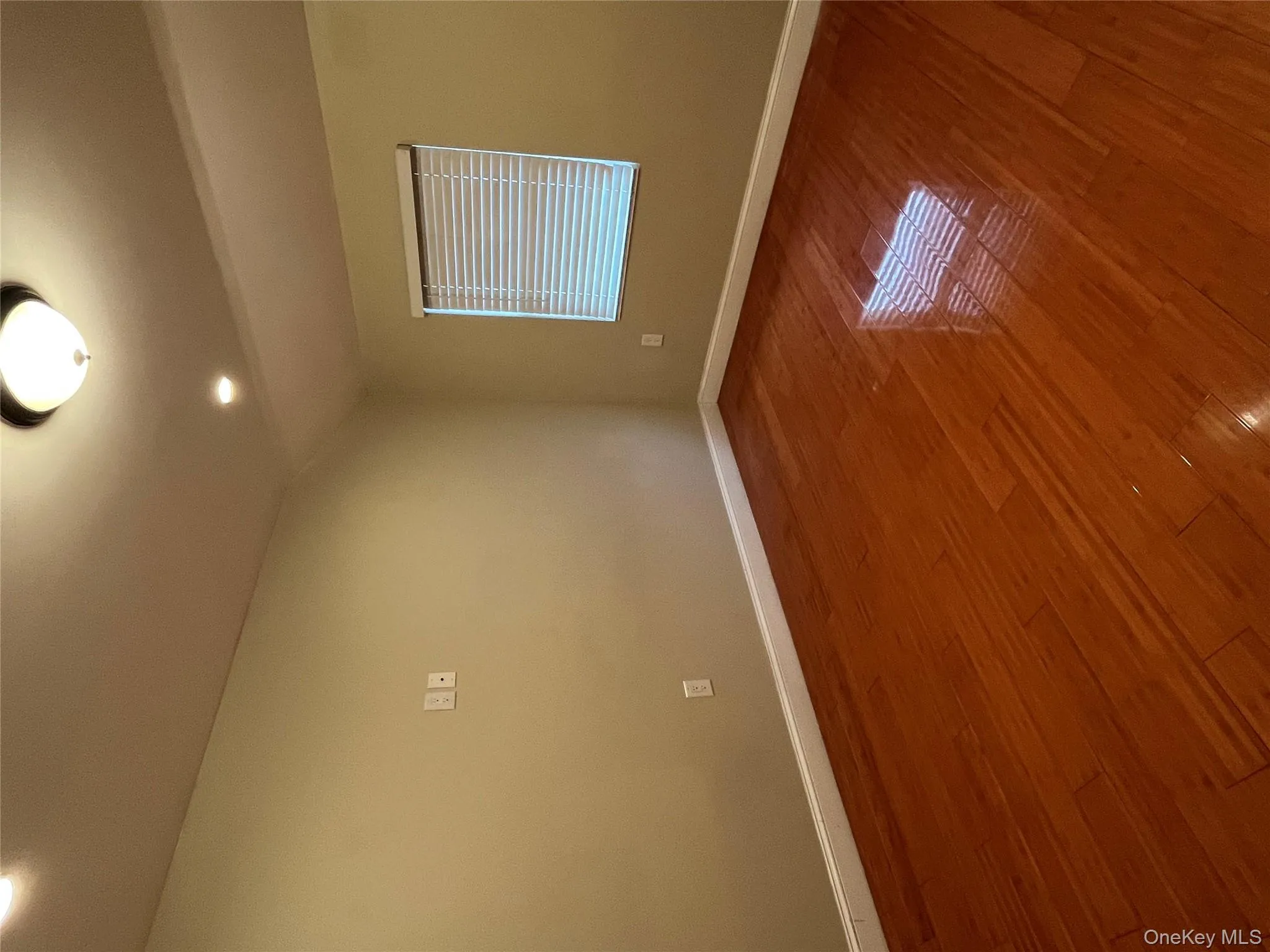 Empty room featuring wood finished floors, vaulted ceiling, and recessed lighting Empty room featuring wood finished floors, vaulted ceiling, and recessed lighting