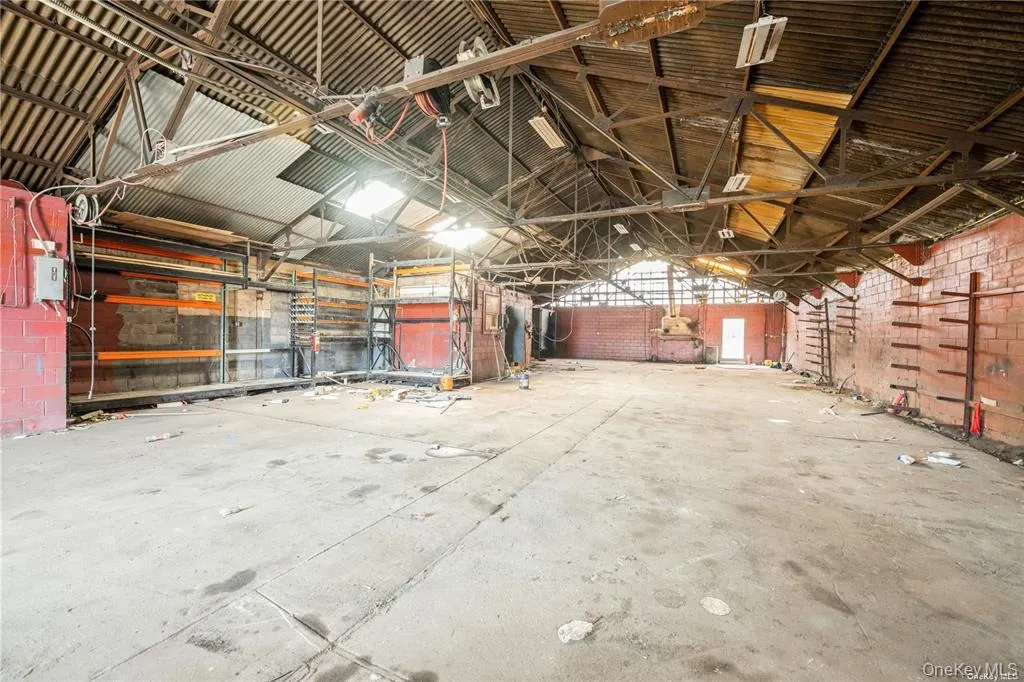 Miscellaneous room featuring lofted ceiling, metal wall, and a garage Miscellaneous room featuring lofted ceiling, metal wall, and a garage
