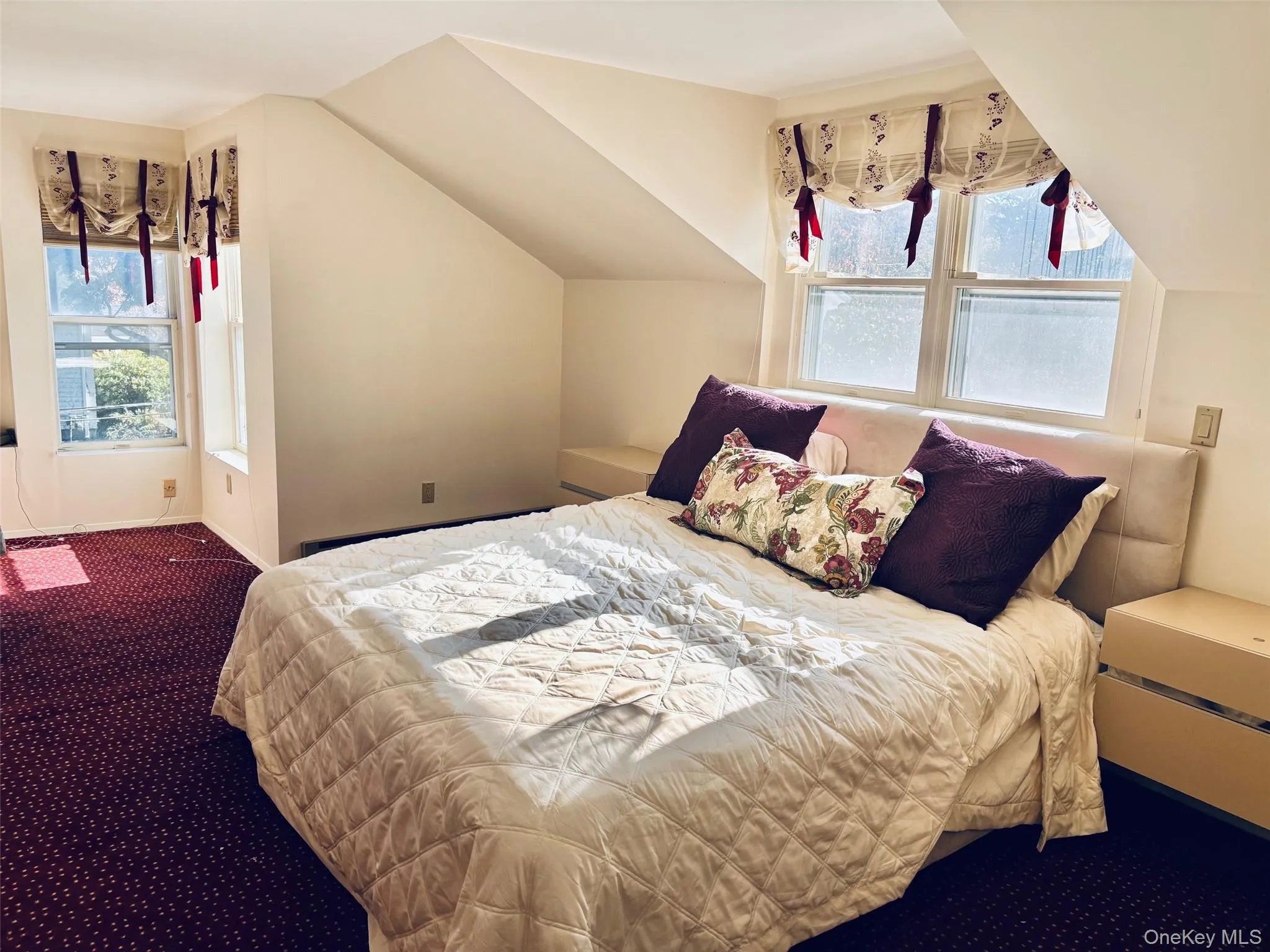 Bedroom featuring dark colored carpet and lofted ceiling Bedroom featuring dark colored carpet and lofted ceiling