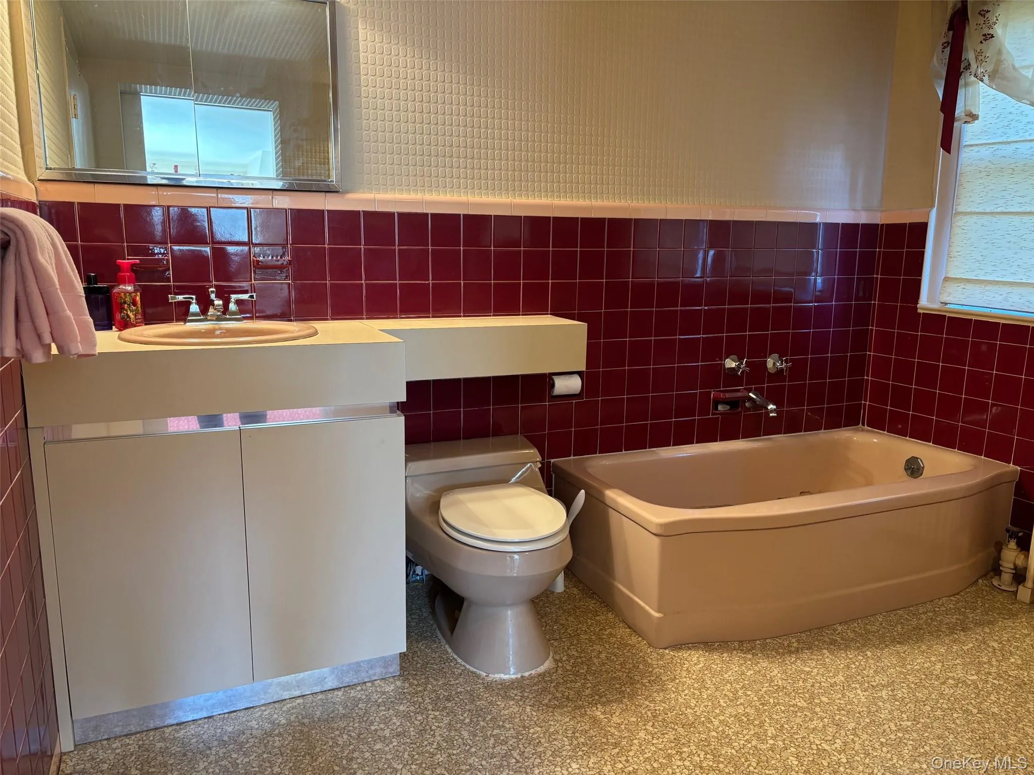 Bathroom featuring tile walls, vanity, a garden tub, and a wainscoted wall Bathroom featuring tile walls, vanity, a garden tub, and a wainscoted wall