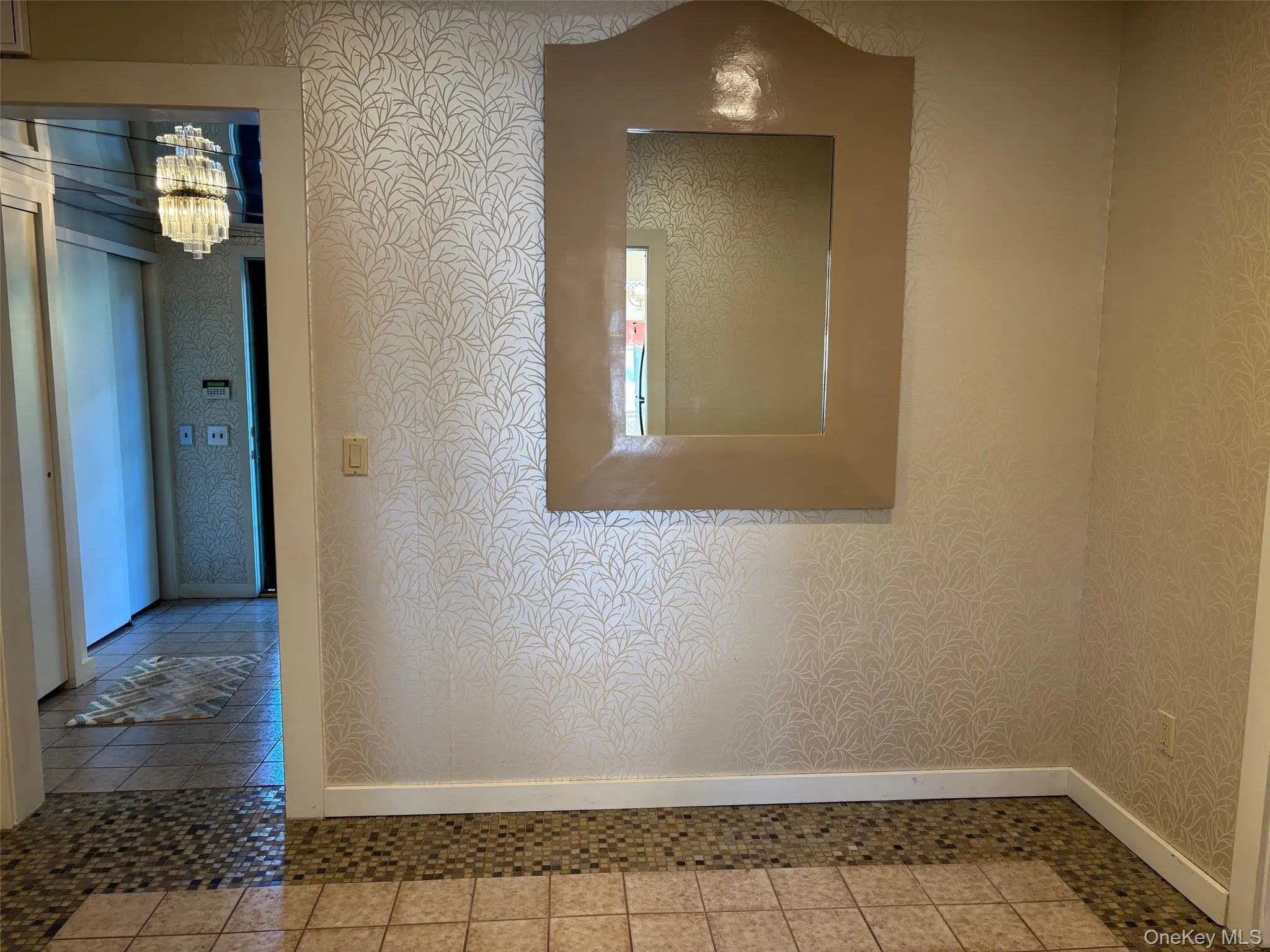 Corridor with a chandelier, wallpapered walls, and tile patterned flooring Corridor with a chandelier, wallpapered walls, and tile patterned flooring