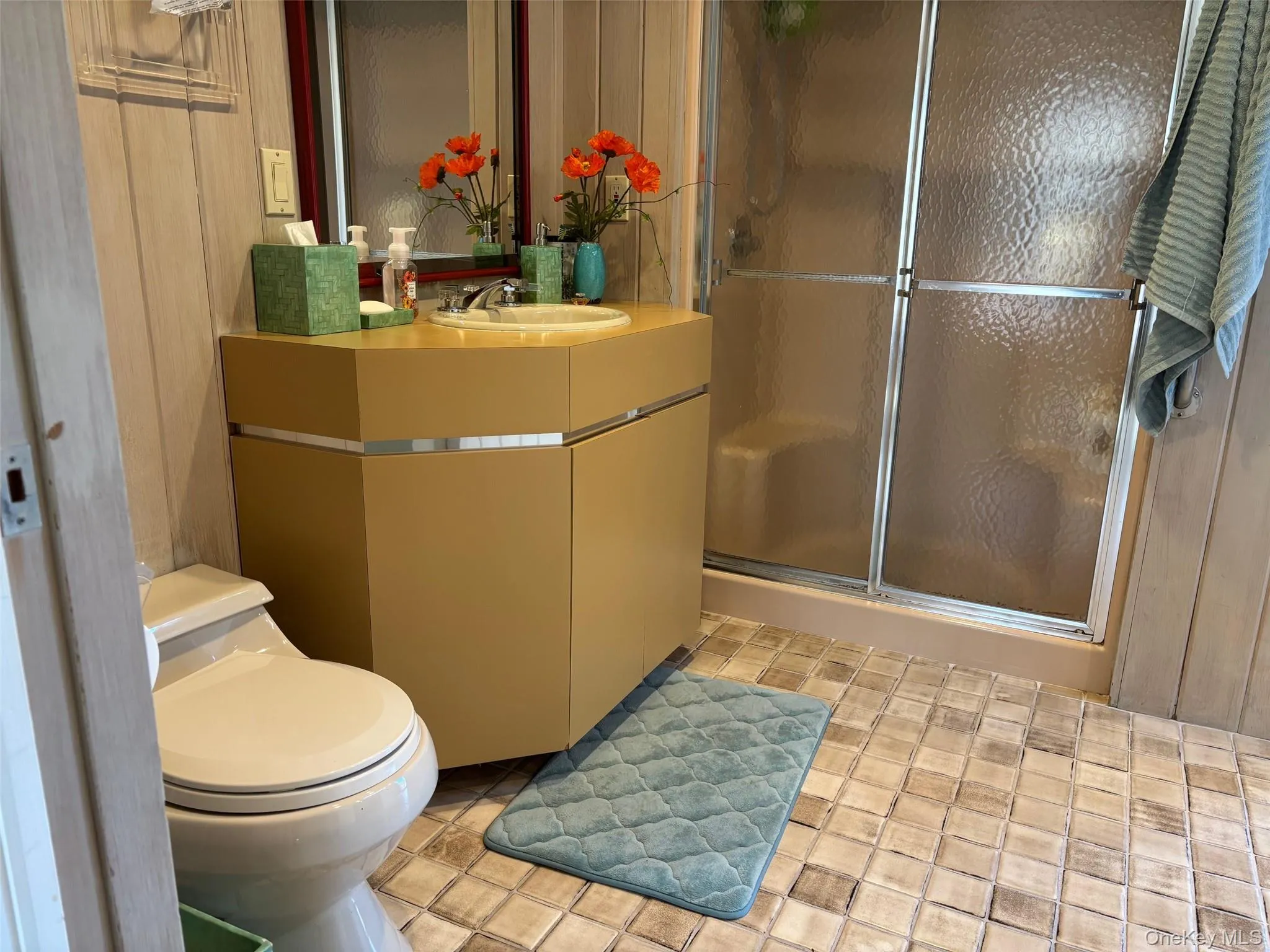 Bathroom featuring a shower stall, vanity, and light tile patterned floors Bathroom featuring a shower stall, vanity, and light tile patterned floors