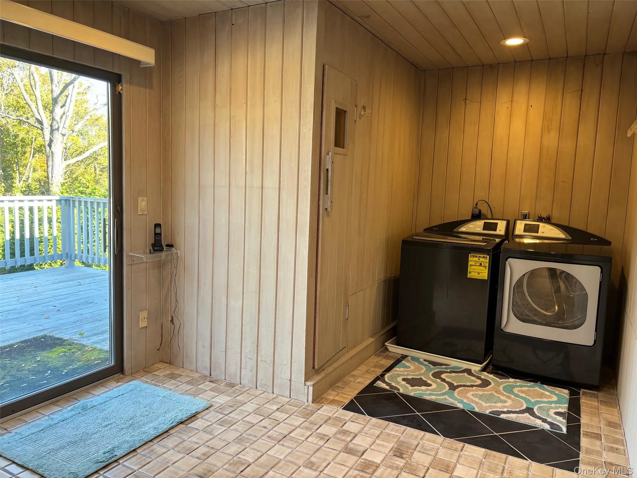Laundry room featuring wood walls, washer and clothes dryer, and wooden ceiling Laundry room featuring wood walls, washer and clothes dryer, and wooden ceiling