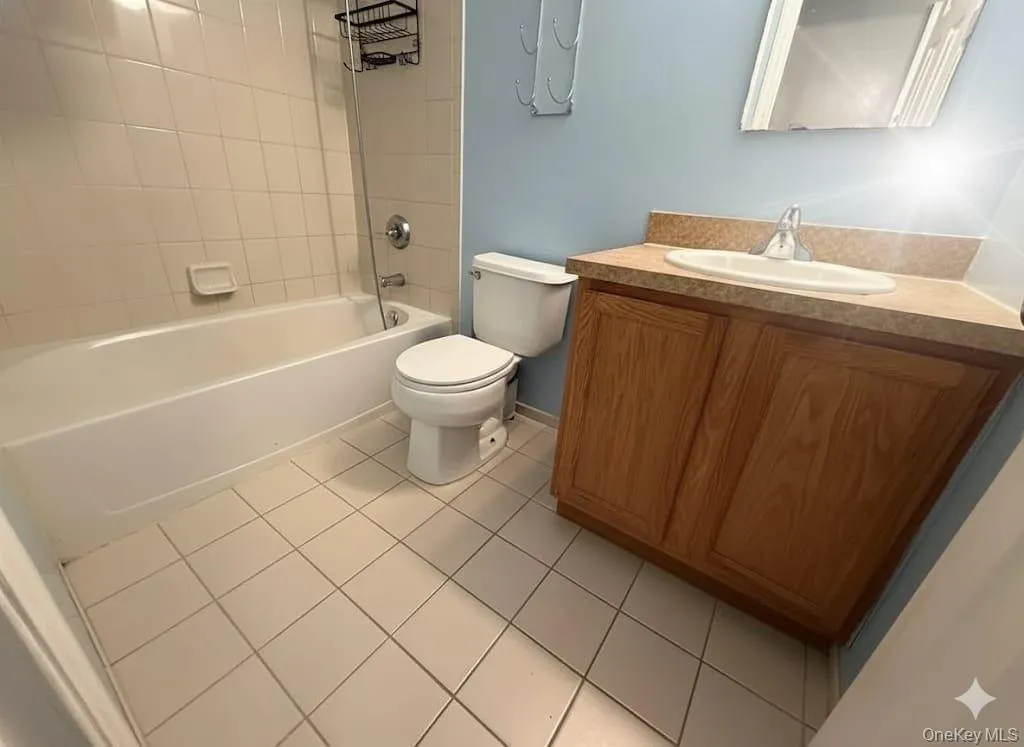 Full bath with light tile patterned floors, vanity, and shower combination Full bath with light tile patterned floors, vanity, and shower combination