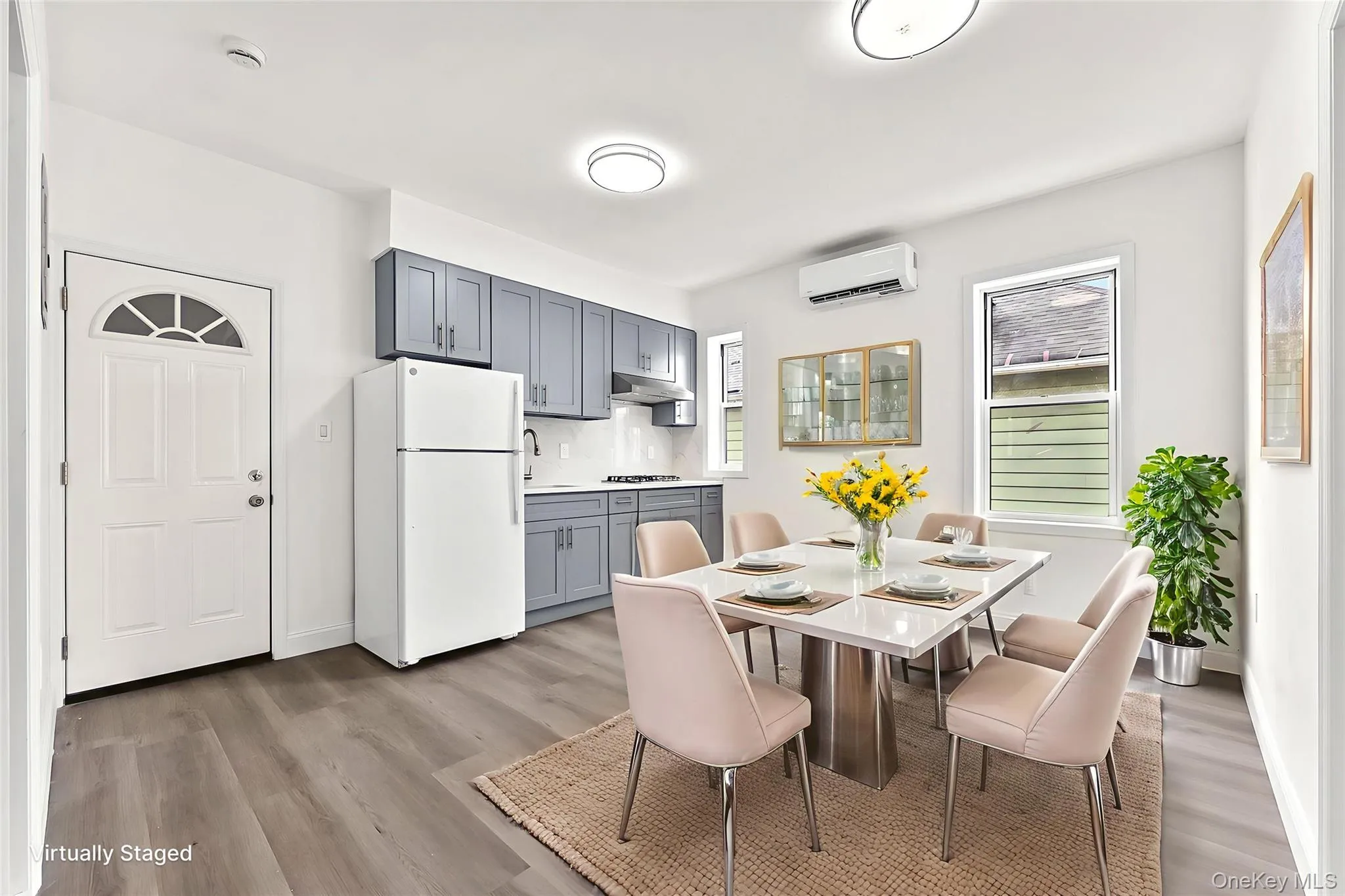 Dining space with light wood finished floors and a wall unit AC Dining space with light wood finished floors and a wall unit AC