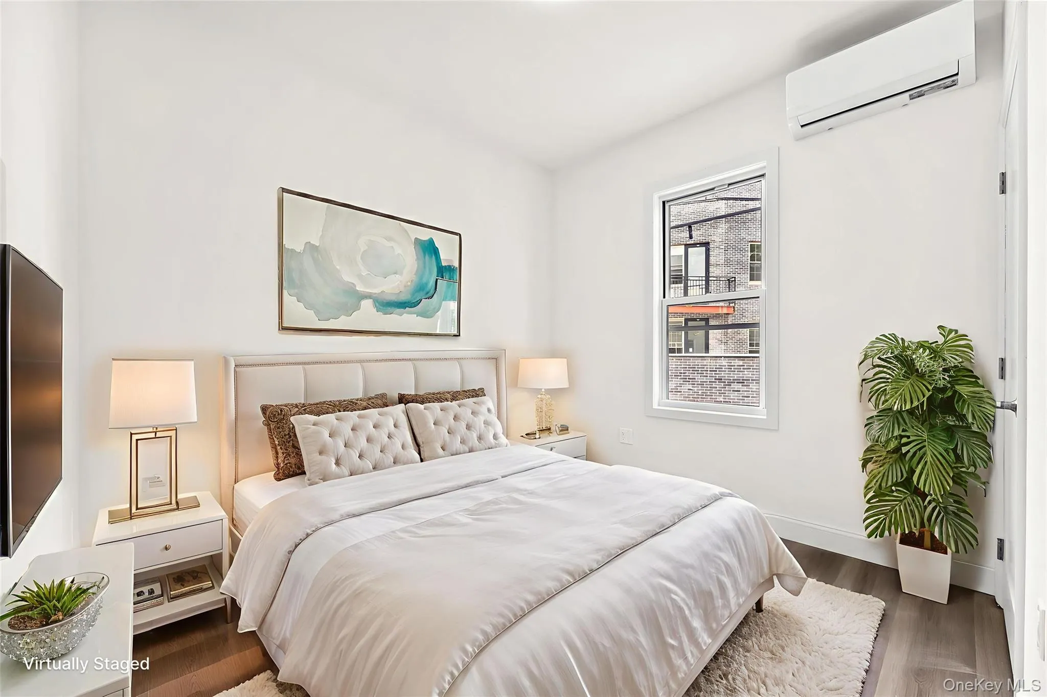 Bedroom with a wall mounted air conditioner and wood finished floors Bedroom with a wall mounted air conditioner and wood finished floors