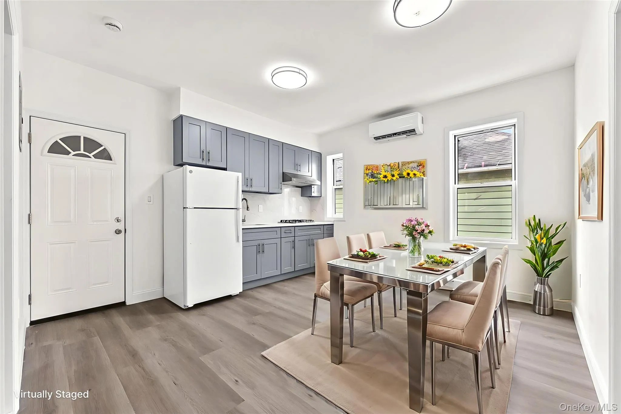 Dining area with plenty of natural light, light wood finished floors, and a wall mounted AC Dining area with plenty of natural light, light wood finished floors, and a wall mounted AC