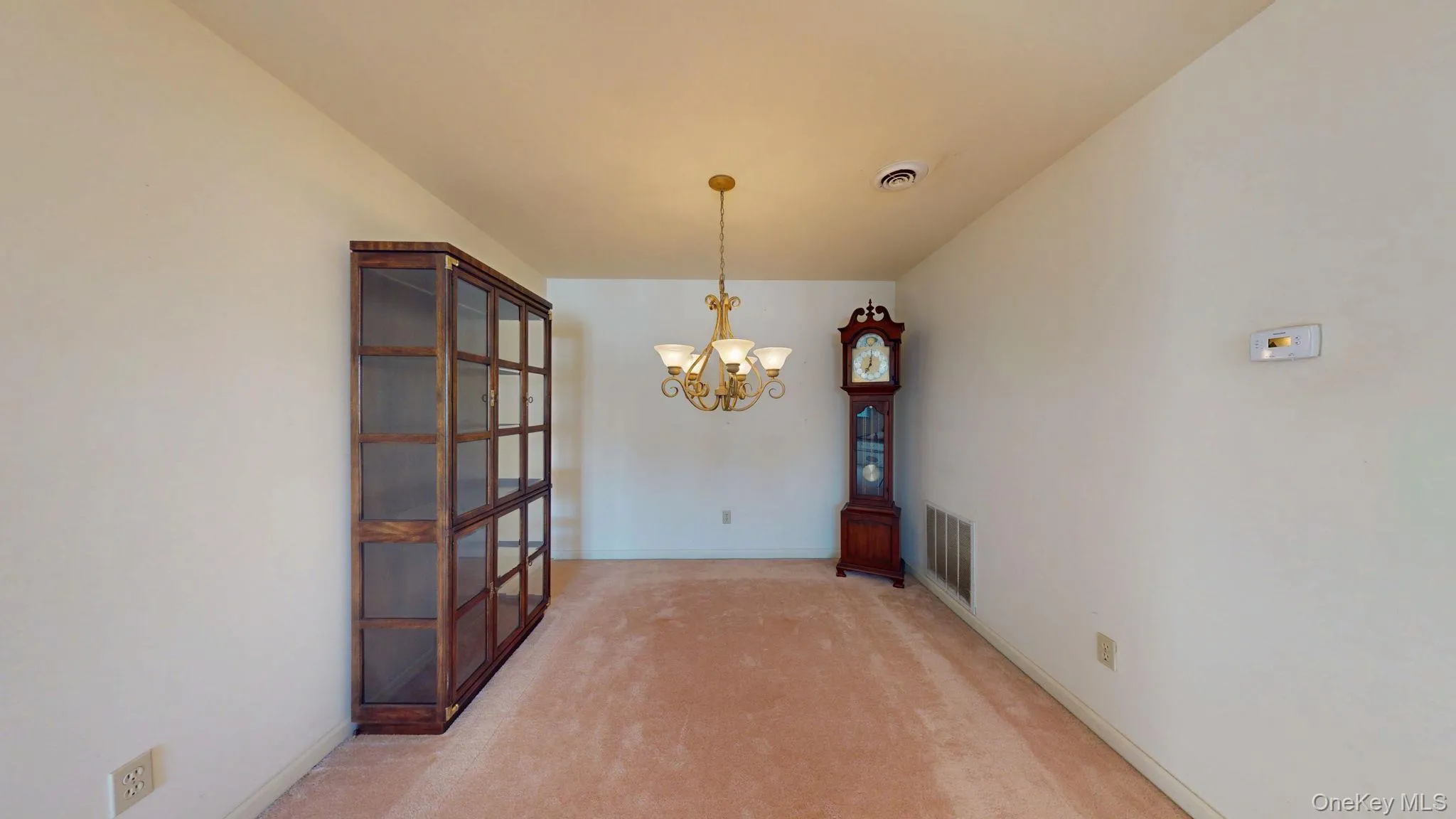 Unfurnished dining area with a chandelier and light carpet Unfurnished dining area with a chandelier and light carpet