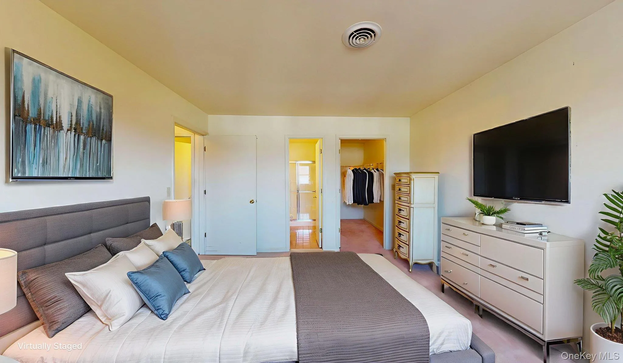 Carpeted bedroom with a walk in closet and ensuite bathroom Carpeted bedroom with a walk in closet and ensuite bathroom