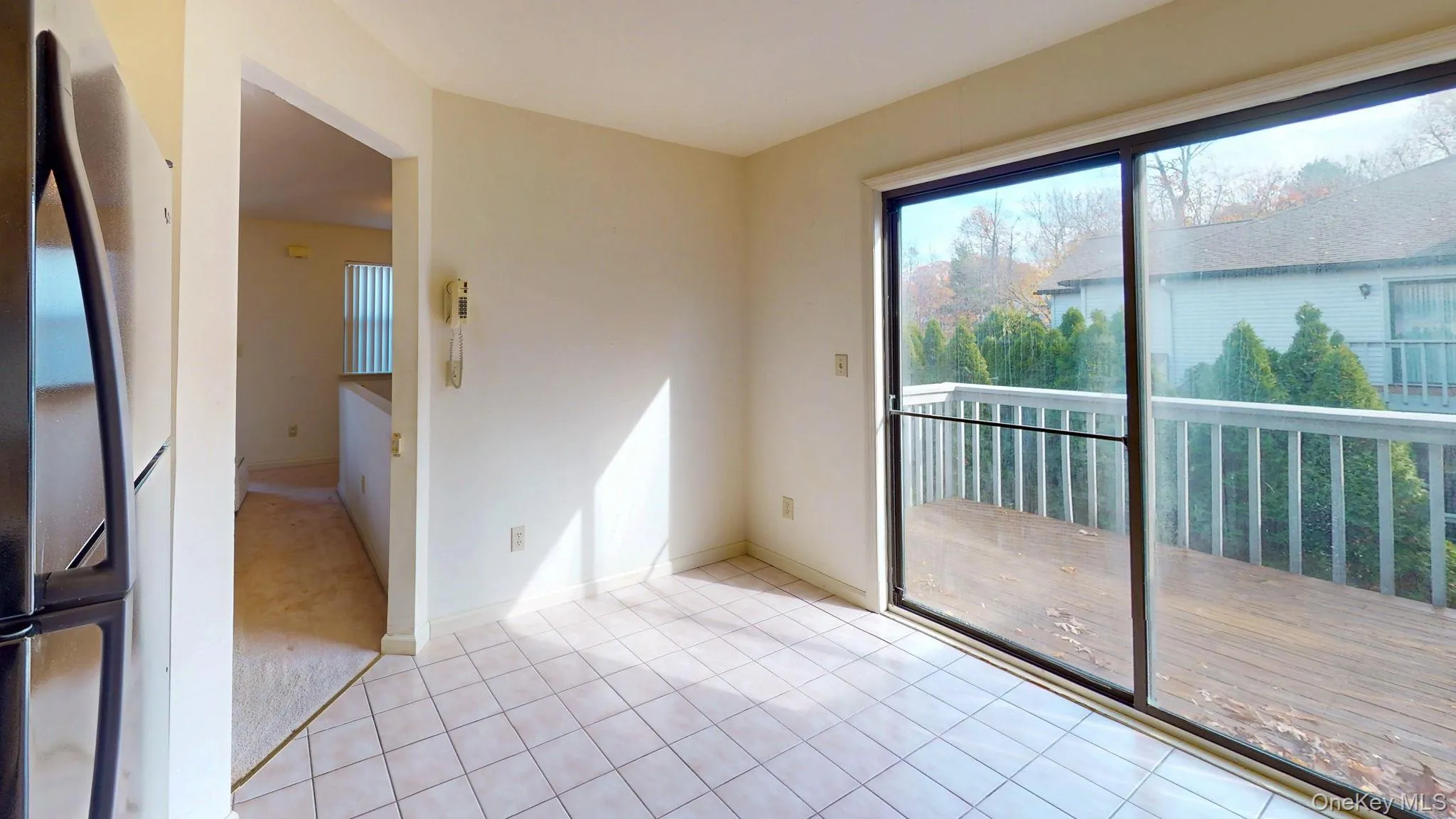 Spare room with light tile patterned floors and light colored carpet Spare room with light tile patterned floors and light colored carpet