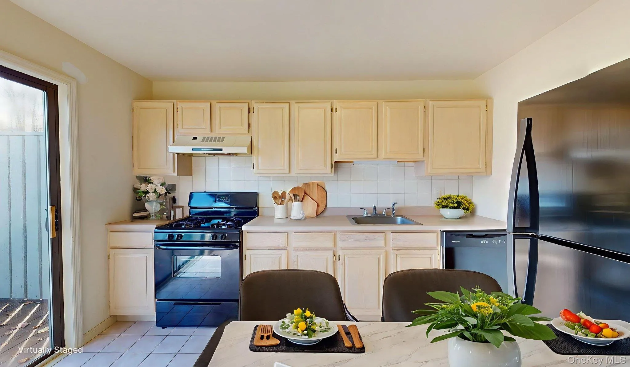 Kitchen featuring black appliances, light countertops, and backsplash Kitchen featuring black appliances, light countertops, and backsplash
