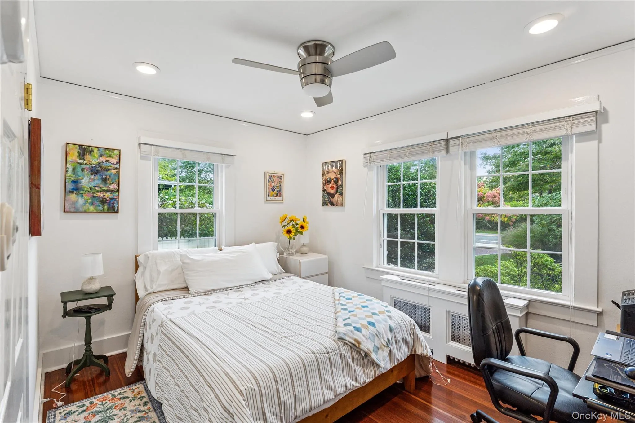 Bedroom featuring wood finished floors, ceiling fan, recessed lighting, radiator heating unit, and an office area Bedroom featuring wood finished floors, ceiling fan, recessed lighting, radiator heating unit, and an office area