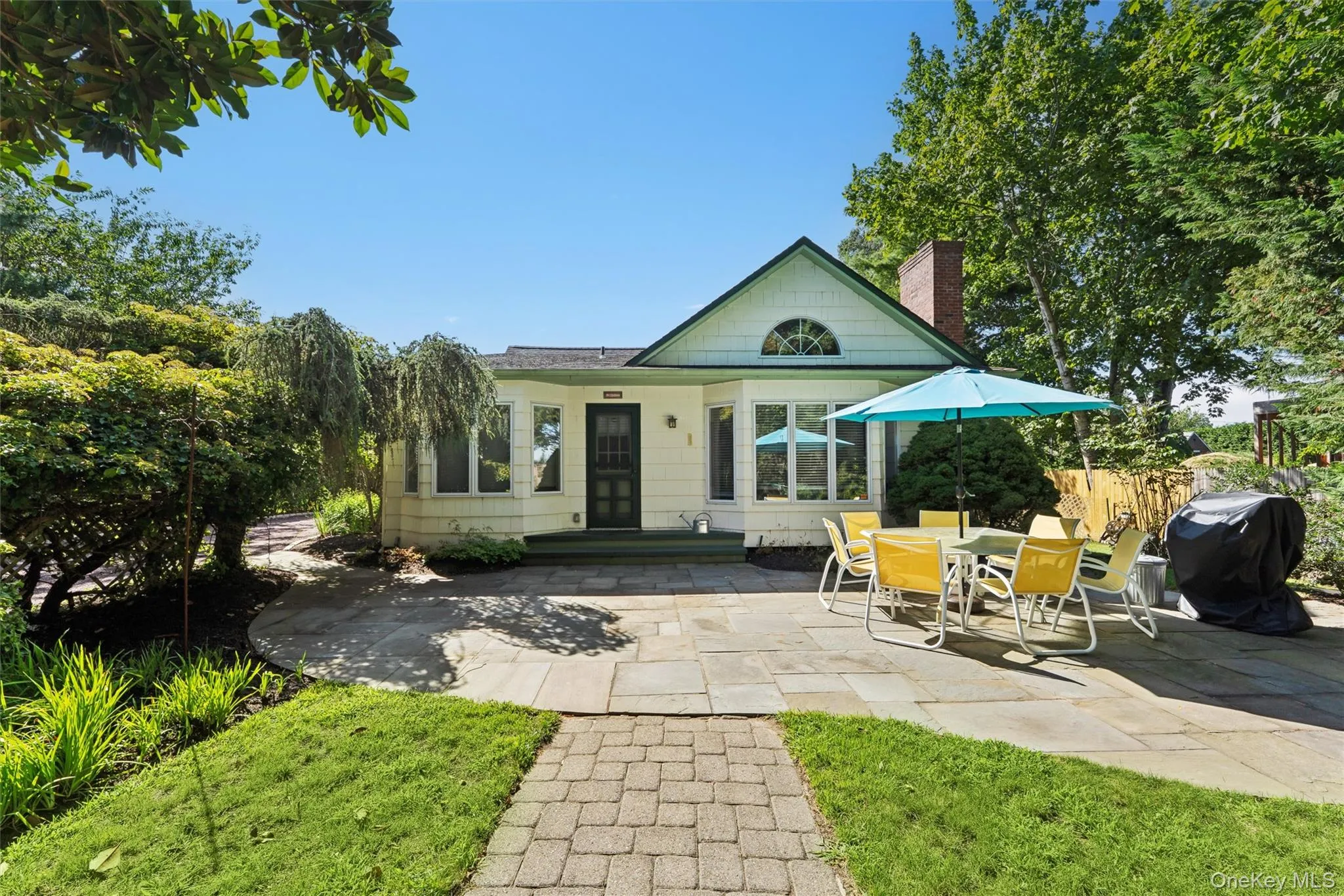 View of front of house featuring a patio area and a chimney View of front of house featuring a patio area and a chimney