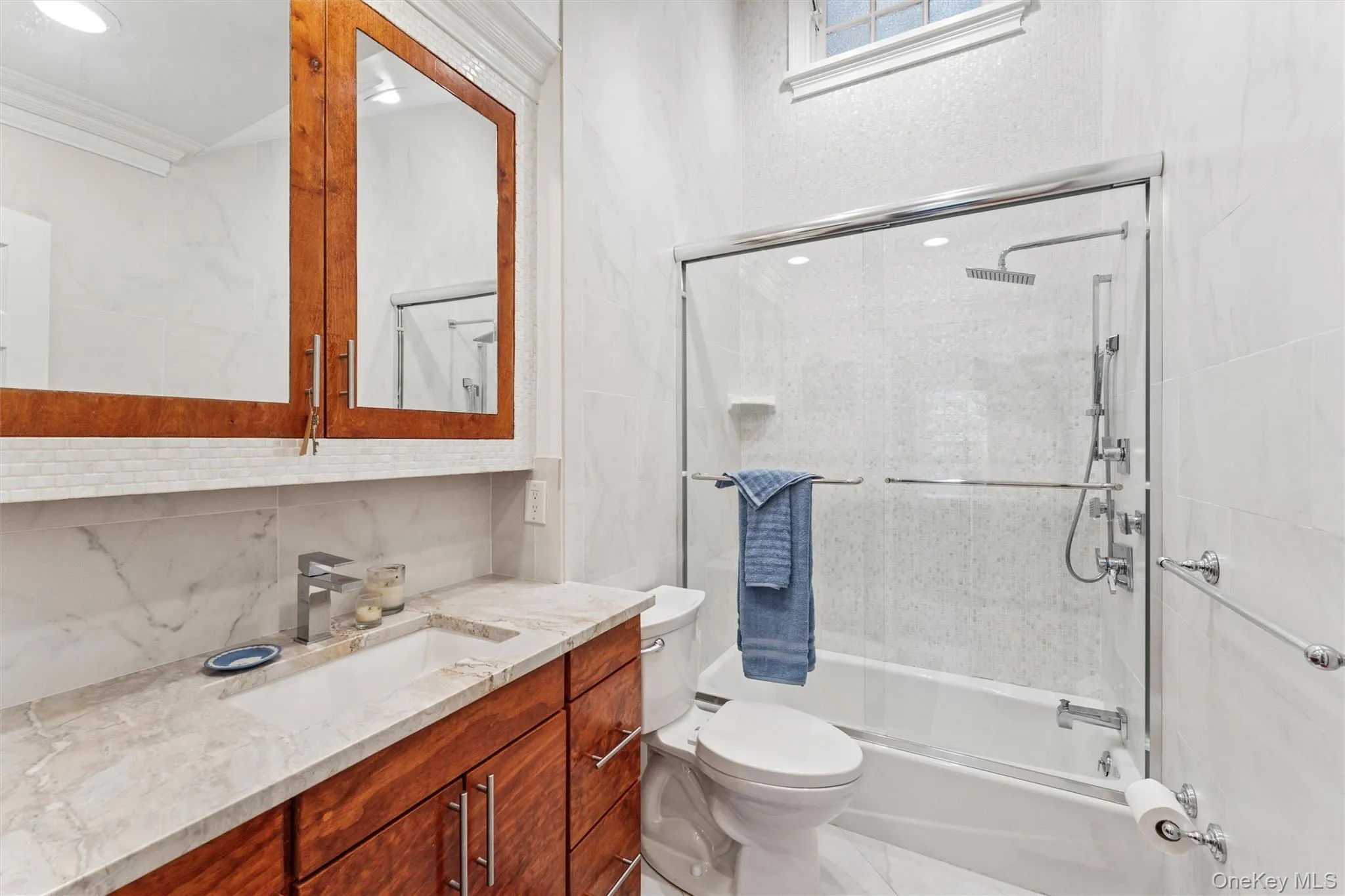 Bathroom with shower / bath combination with glass door, decorative backsplash, vanity, crown molding, and recessed lighting Bathroom with shower / bath combination with glass door, decorative backsplash, vanity, crown molding, and recessed lighting