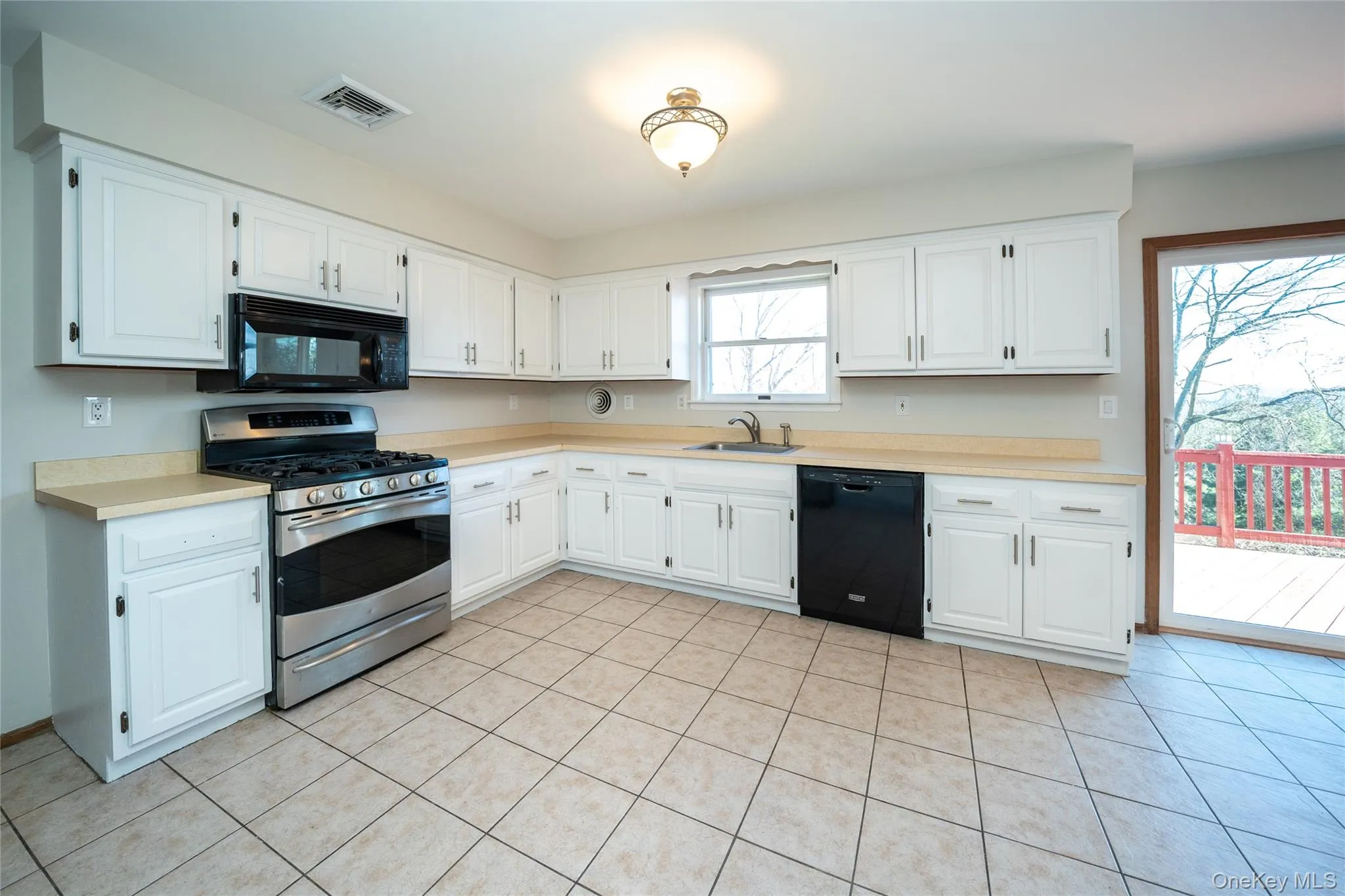 Kitchen featuring black appliances, light countertops, and white cabinets Kitchen featuring black appliances, light countertops, and white cabinets