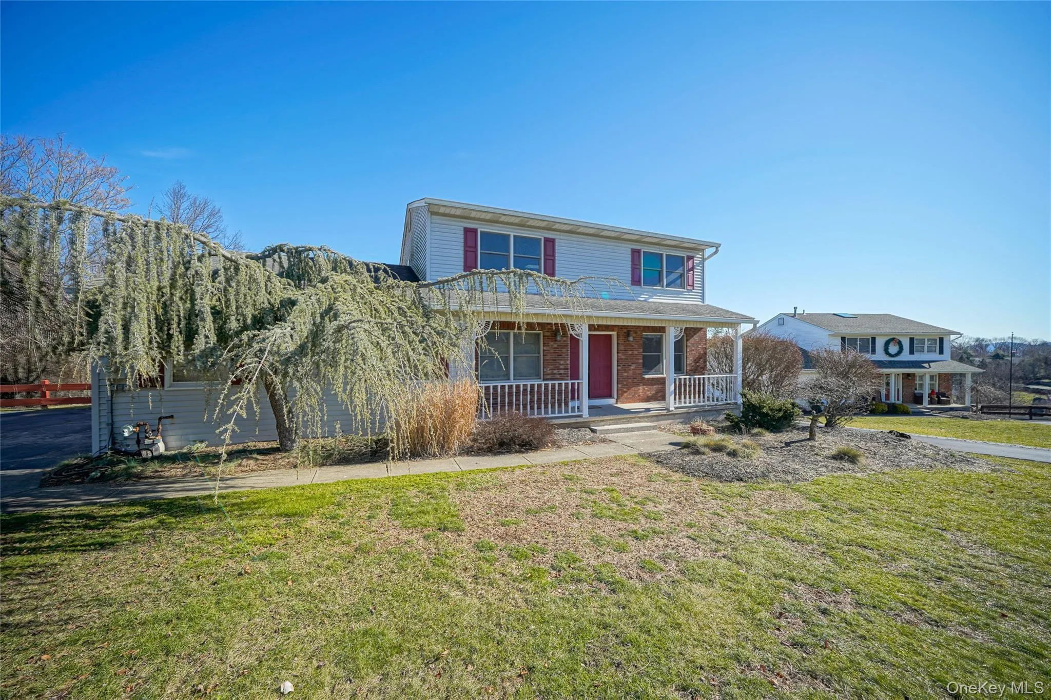 View of front of home featuring a porch, a front lawn, and brick siding View of front of home featuring a porch, a front lawn, and brick siding
