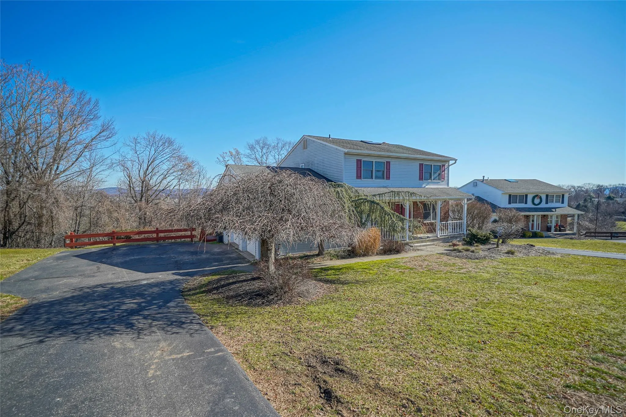 View of front of home with a porch, a front lawn, asphalt driveway, and a garage View of front of home with a porch, a front lawn, asphalt driveway, and a garage