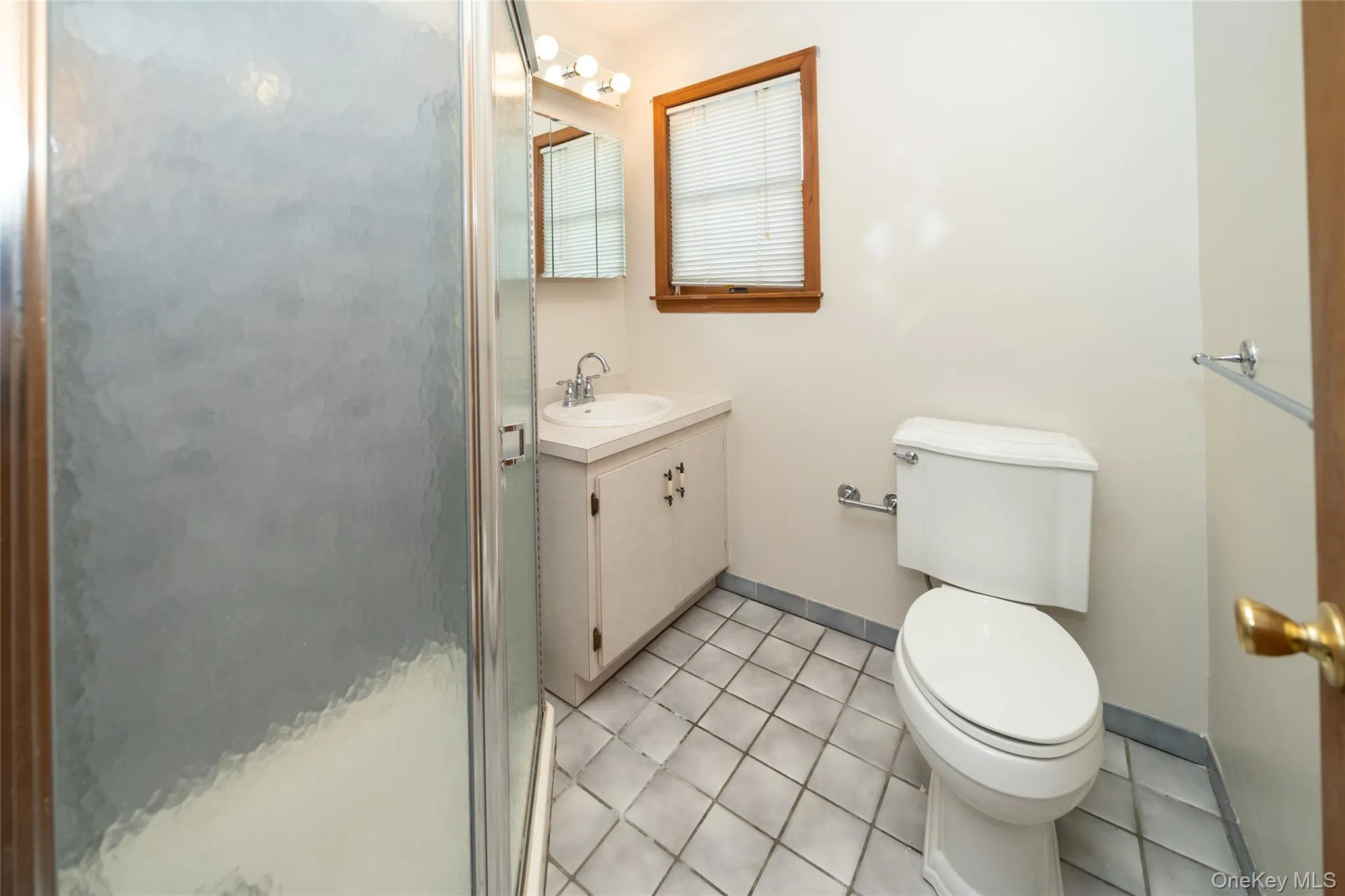 Full bath featuring light tile patterned flooring, vanity, and a stall shower Full bath featuring light tile patterned flooring, vanity, and a stall shower