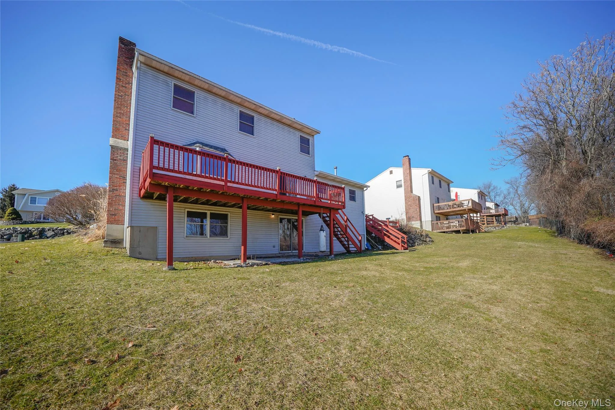 Rear view of house featuring a deck, a lawn, stairs, and a patio area Rear view of house featuring a deck, a lawn, stairs, and a patio area