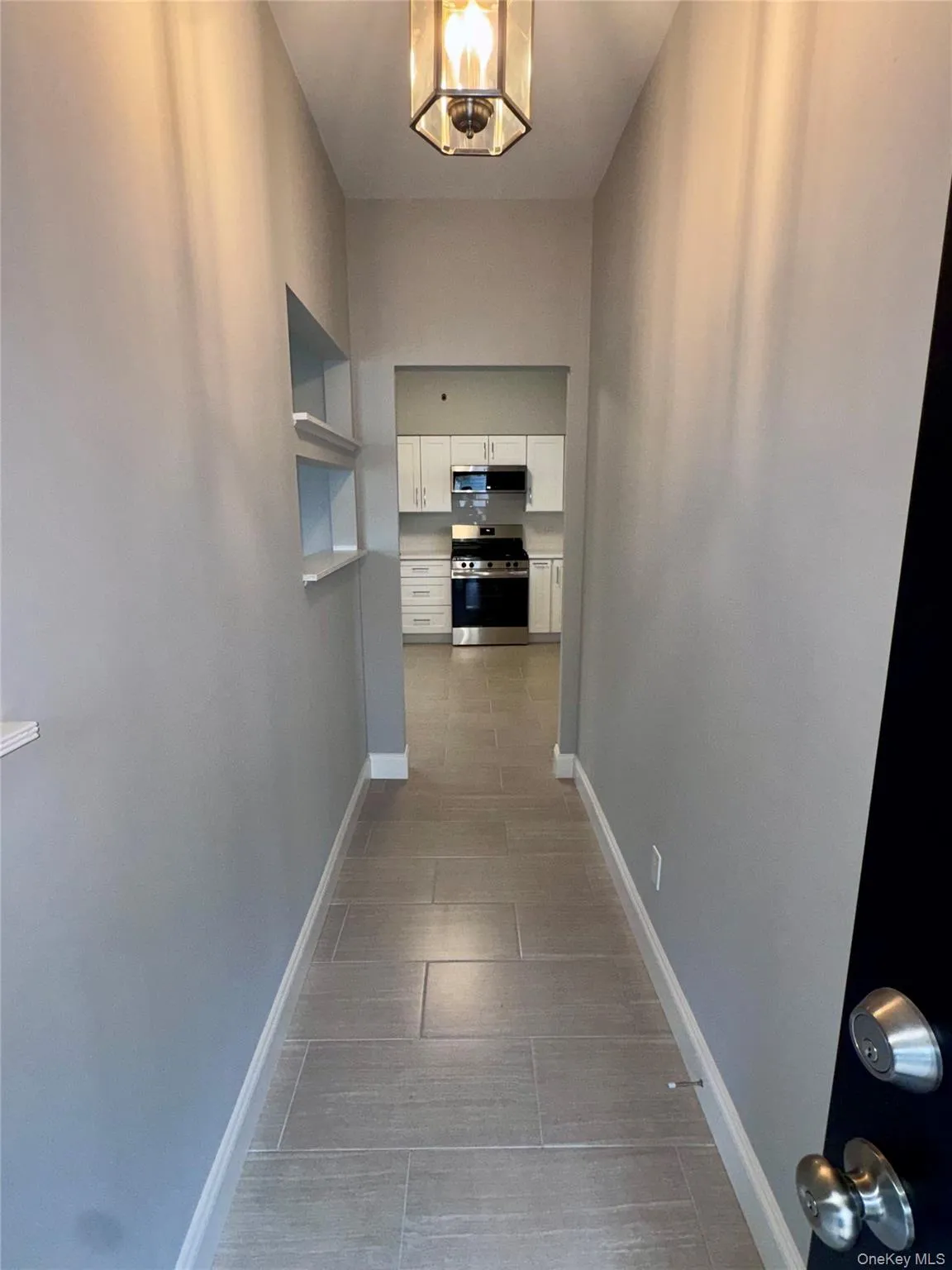 Main Entrance Hall with baseboards and dark tile patterned floors Main Entrance Hall with baseboards and dark tile patterned floors