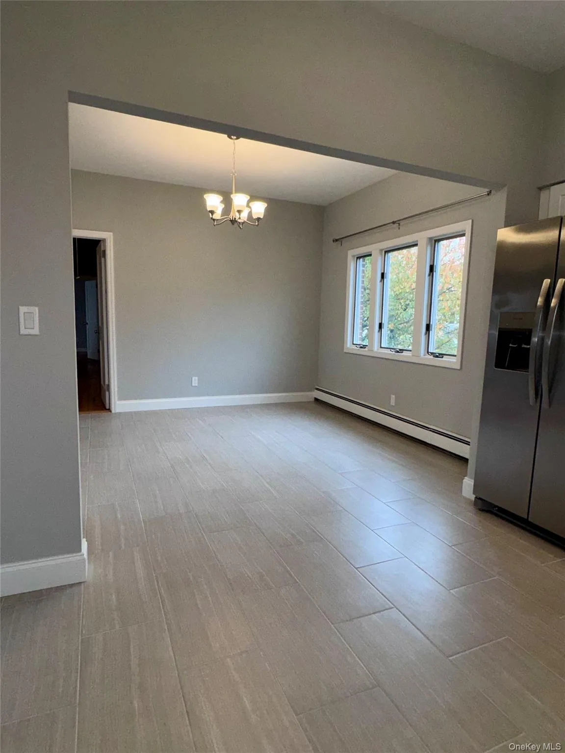 Formal Dining area featuring baseboard heating unit, a chandelier, and light wood finished floors Formal Dining area featuring baseboard heating unit, a chandelier, and light wood finished floors