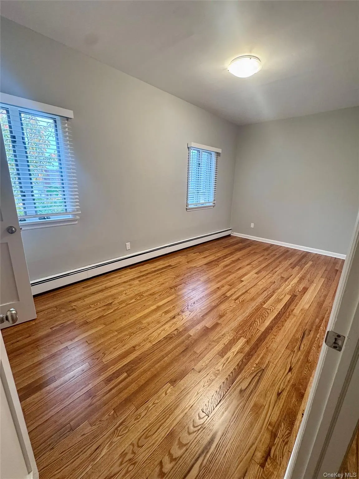 Bedroom 2 featuring baseboard heating and light wood-style floors Bedroom 2 featuring baseboard heating and light wood-style floors