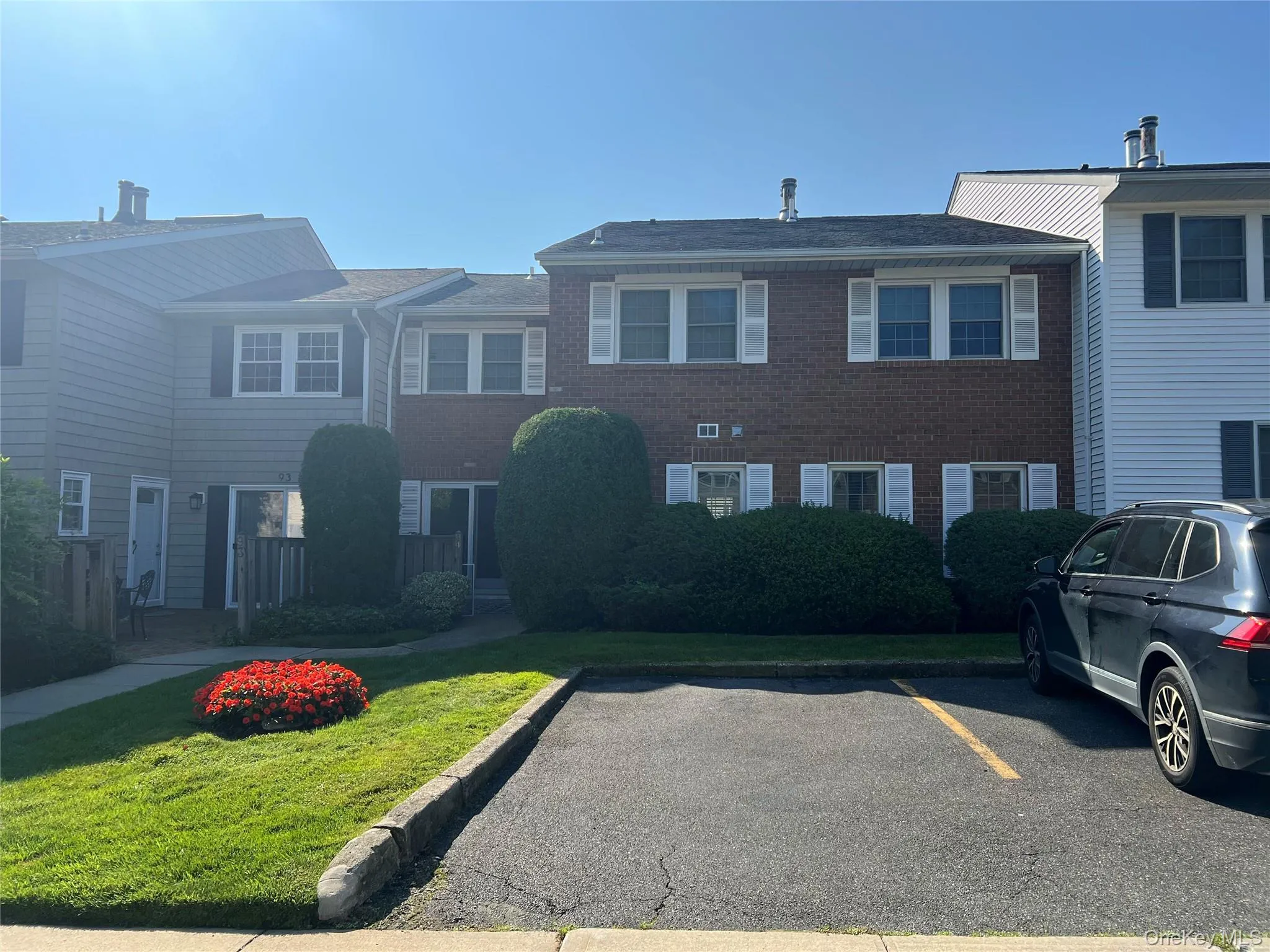 View of front of property with brick siding, a front lawn, and uncovered parking View of front of property with brick siding, a front lawn, and uncovered parking