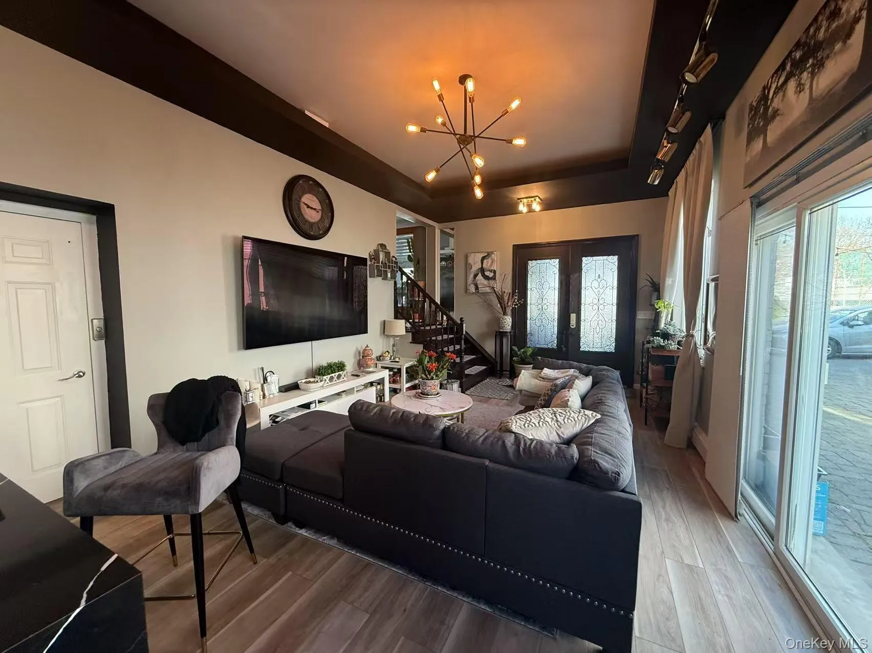 Living area featuring stairs, wood finished floors, and a chandelier Living area featuring stairs, wood finished floors, and a chandelier