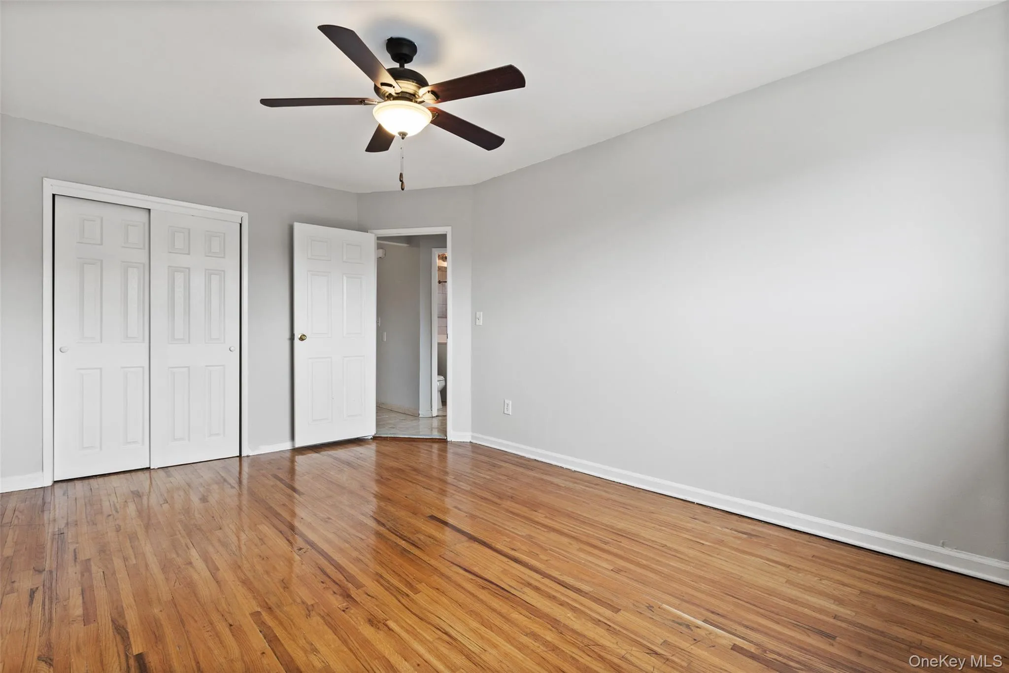 Unfurnished bedroom with light wood finished floors, a ceiling fan, and a closet Unfurnished bedroom with light wood finished floors, a ceiling fan, and a closet