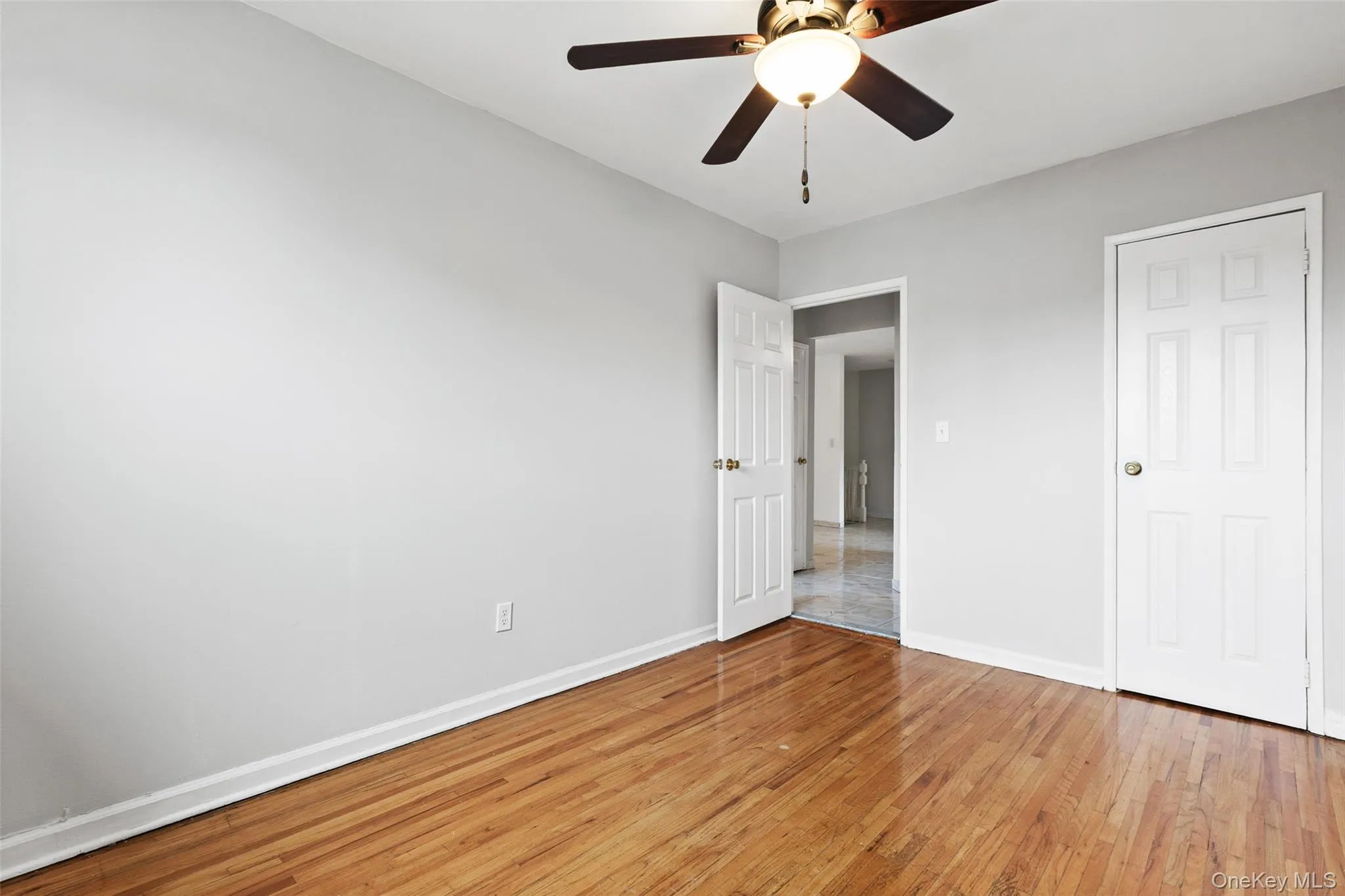 Unfurnished bedroom featuring light wood-style flooring and ceiling fan Unfurnished bedroom featuring light wood-style flooring and ceiling fan