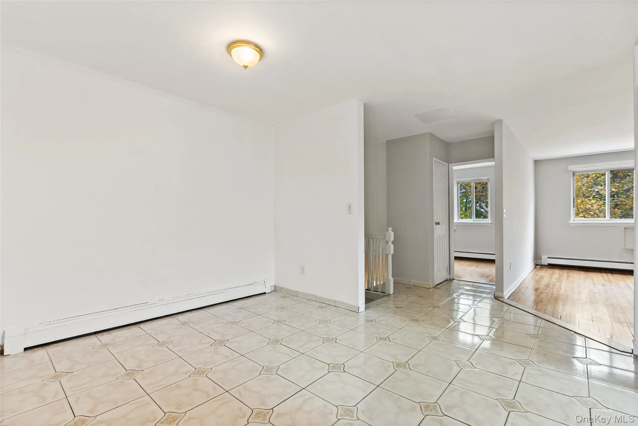Empty room featuring baseboard heating and light tile patterned floors Empty room featuring baseboard heating and light tile patterned floors