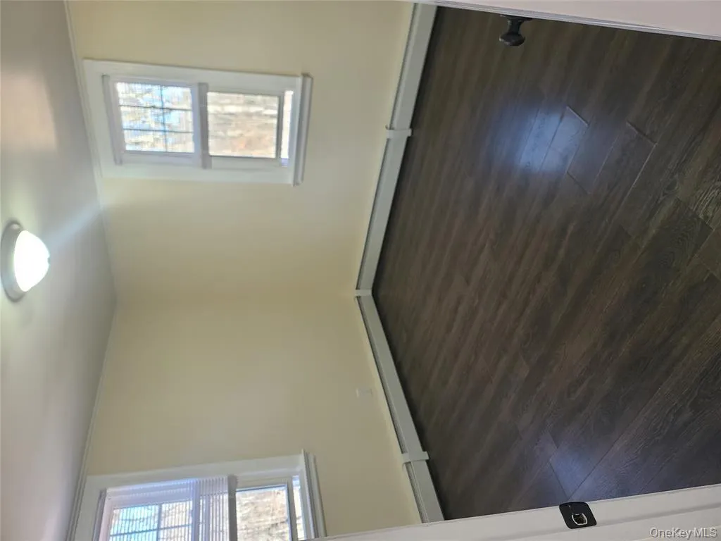 Empty room featuring dark wood-type flooring and a baseboard heating unit Empty room featuring dark wood-type flooring and a baseboard heating unit