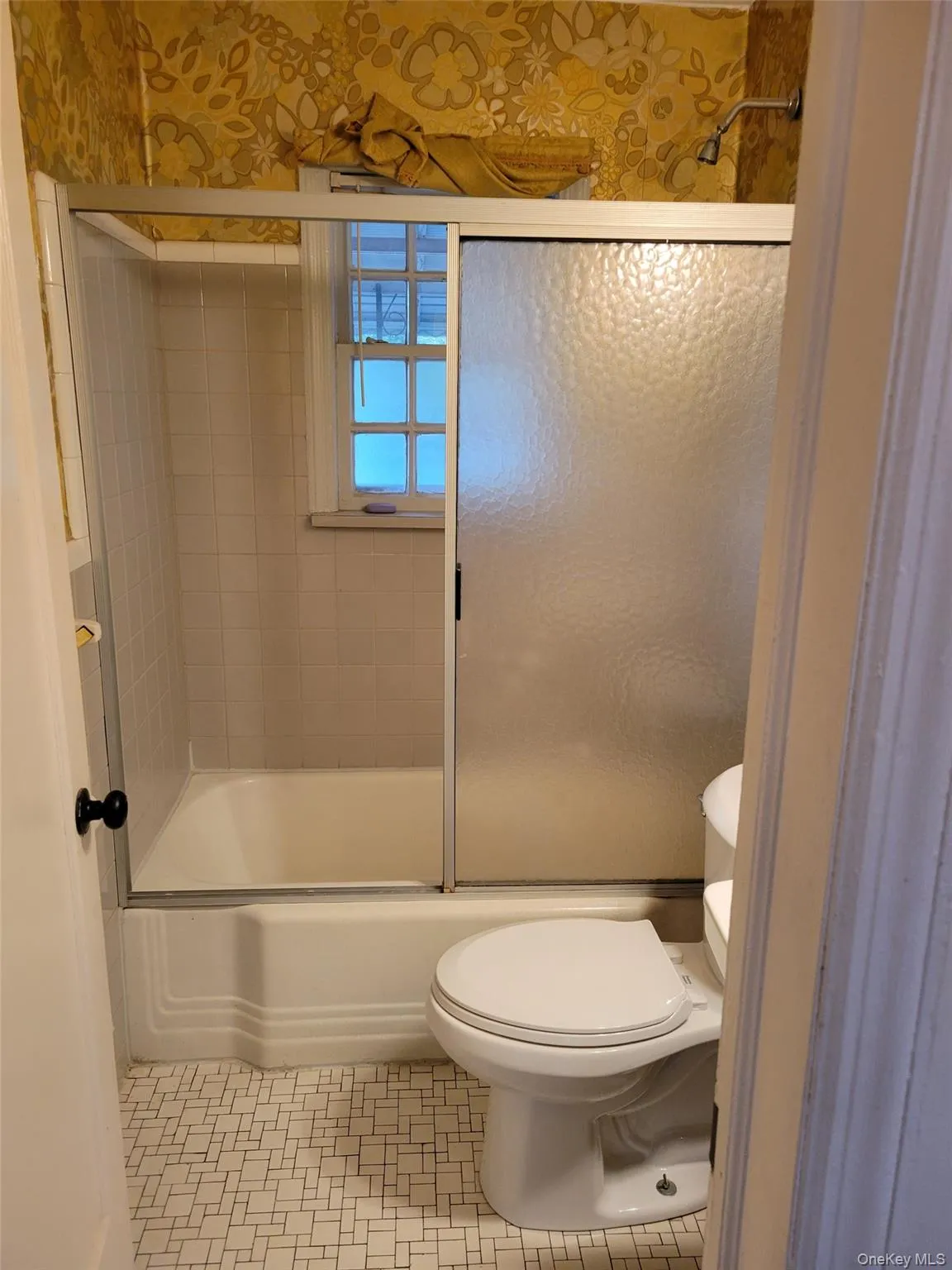 Full bathroom with bath / shower combo with glass door and tile patterned floors Full bathroom with bath / shower combo with glass door and tile patterned floors
